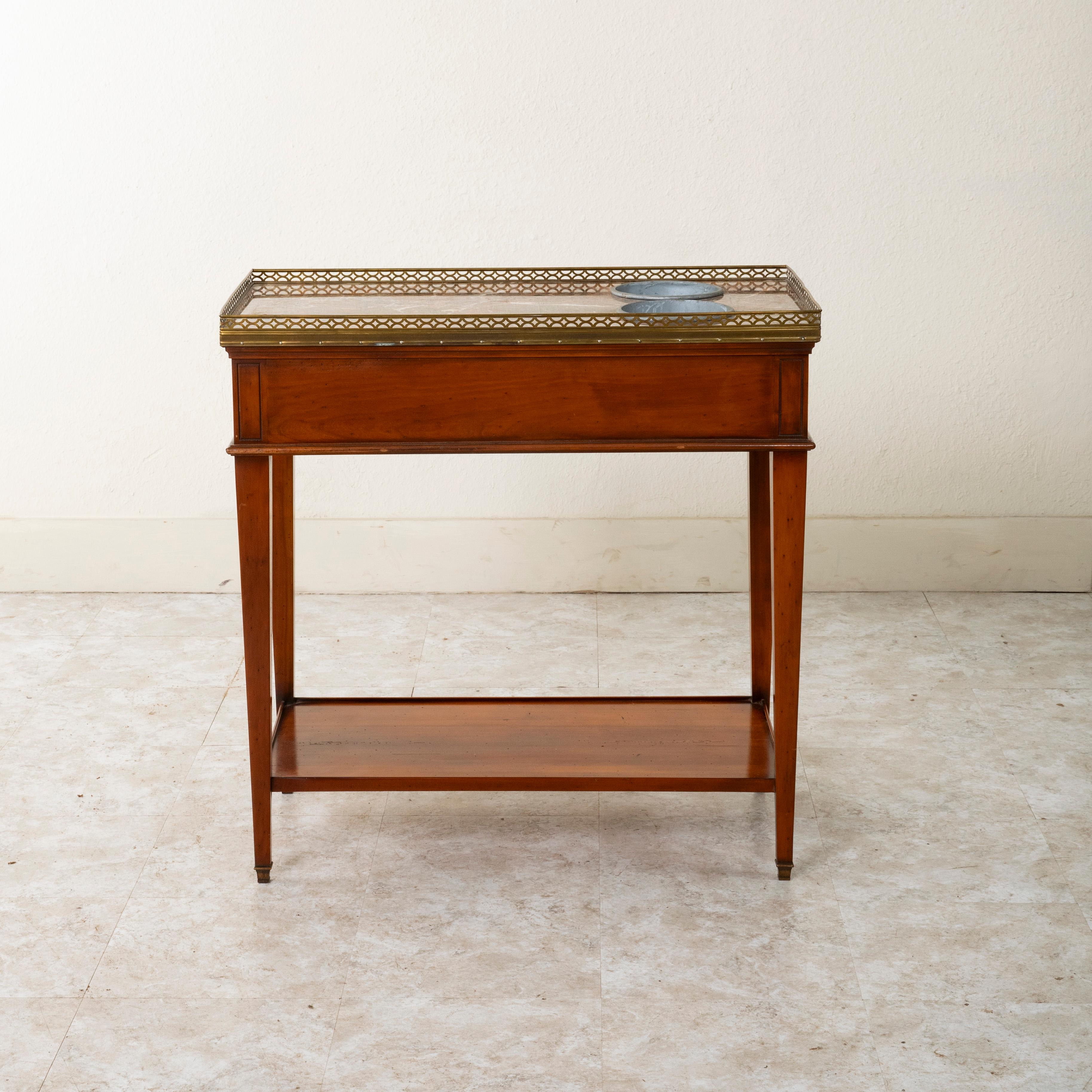 This mid twentieth century Louis XVI style walnut side table features a marble top surrounded by a bronze gallery. Two removable zinc buckets that rest in the marble top serve to chill wine or champagne. A lower shelf and single dovetailed drawer