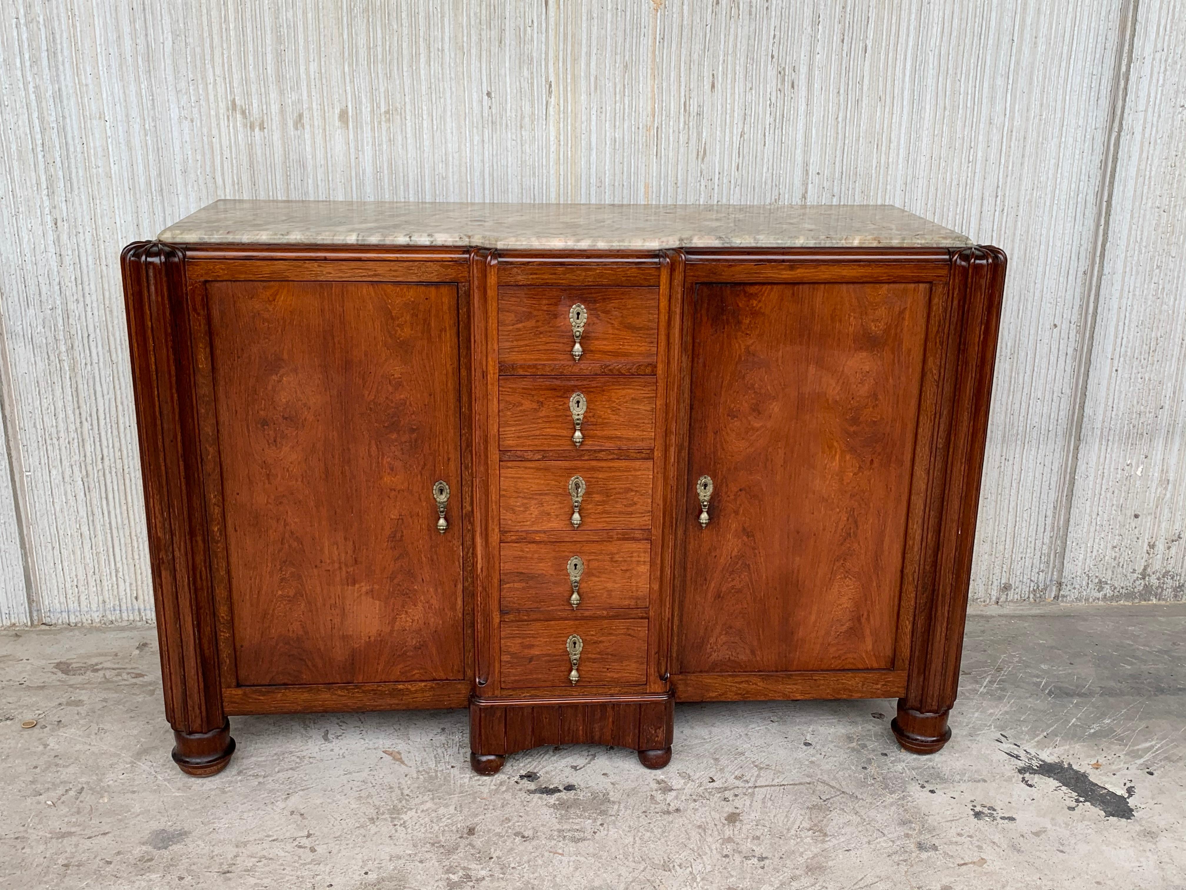 An Art Deco sideboard with burr walnut wood and marble top, with satin fluted columns in both sides and banding. Five integral central drawers with original moss green handles.

We have a matching big one.