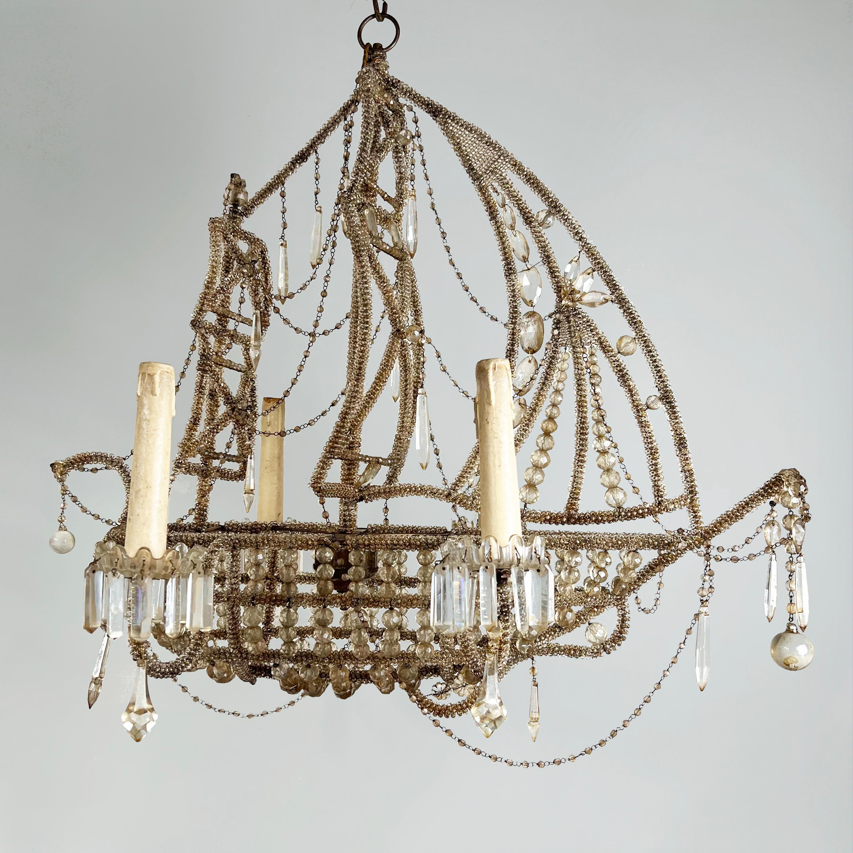 A stunning and highly unusual Mid-Century French ship or galleon chandelier in the style of Maison Bagues.

With an abundance of faceted cut-glass beads and swags. The scrolling electrified arms with glass drip pans hung with elongated faceted