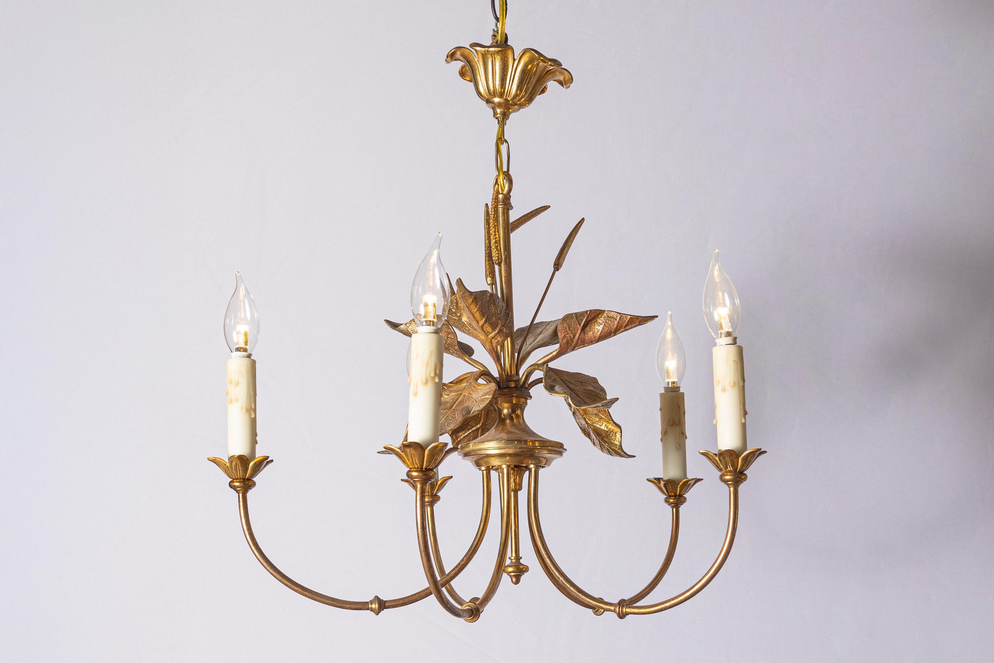 Esta impresionante lámpara de araña francesa del siglo XX se inspira en los elegantes diseños de la Maison Charles. El centro de mesa tiene un tallo de metal dorado adornado con hojas minuciosamente detalladas, que desprenden el atractivo