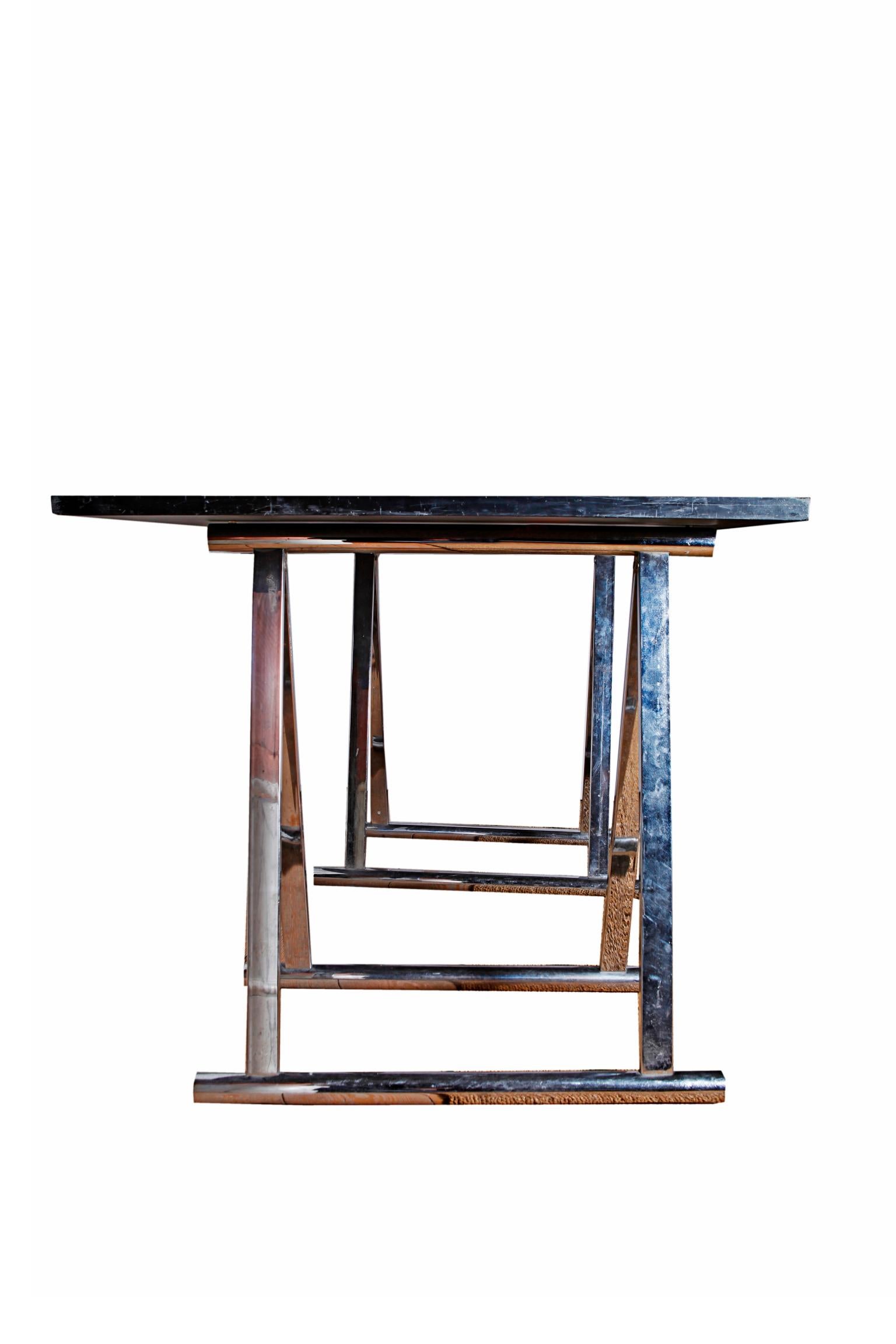 A French Maison Jansen desk. A slate rectangular top supported by a pair of chromed steel bases or trestle foots, circa 1970.