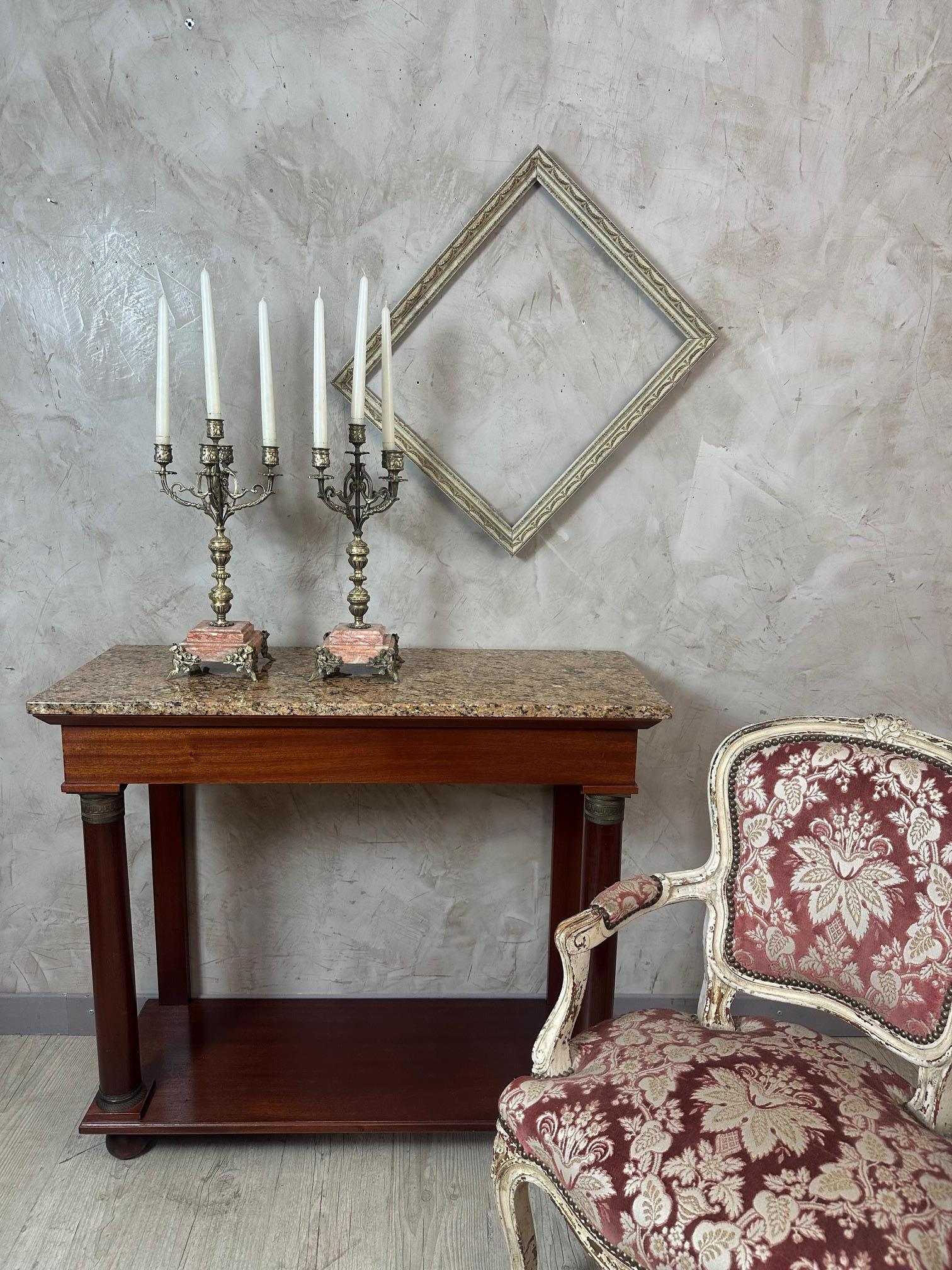 Splendida coppia di candelabri a cinque bracci risalenti agli anni '40, che combinano eleganza e ricchezza decorativa. Le colonne in metallo dorato finemente cesellato poggiano su grandi basi in marmo rosa, evidenziate da piedi ornati da motivi