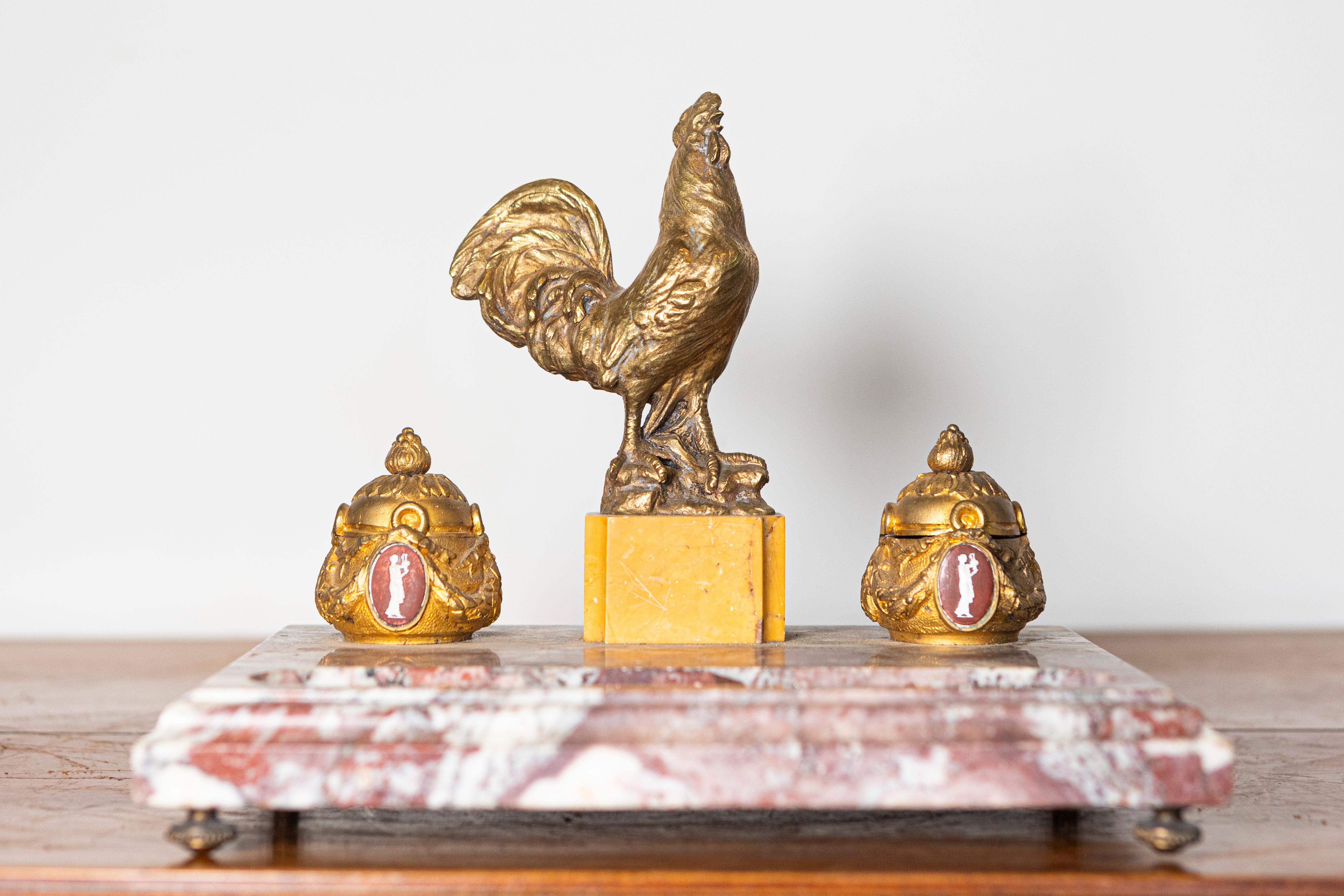 This exquisite 19th-century French inkwell is a striking example of fine craftsmanship, blending luxurious marble and ornate gilt bronze detailing. The substantial marble base, with its rich veining and stepped edges, provides an elegant foundation