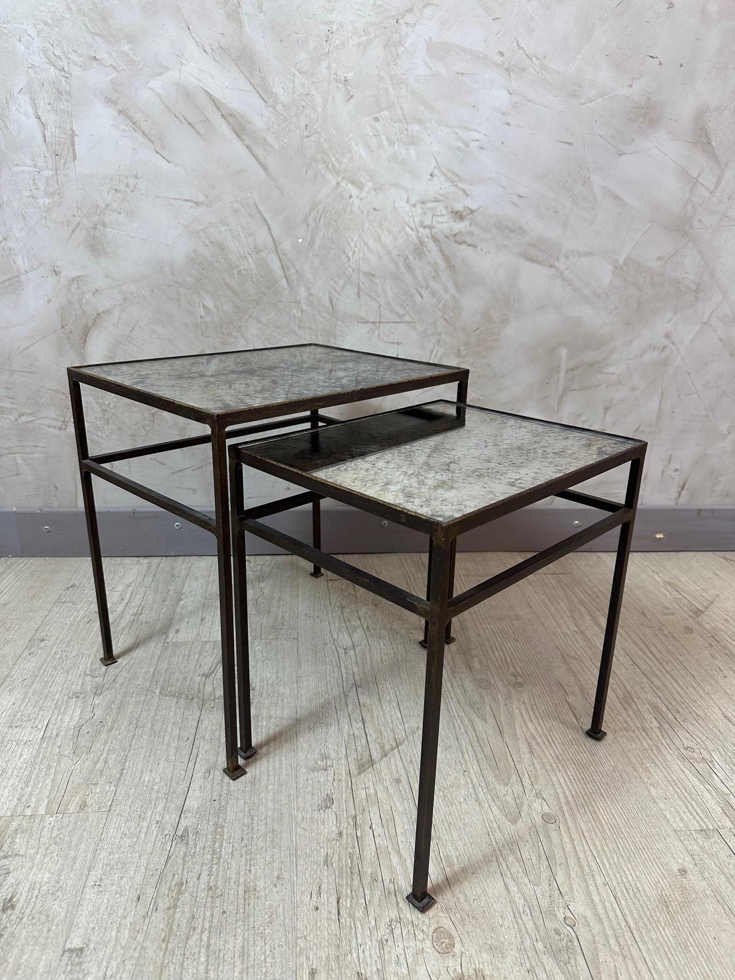 Añade un toque de encanto vintage a tu espacio con este elegante conjunto de dos mesas nido. Con elegantes armazones metálicos y preciosos tableros de espejo envejecido (cristal de mercurio), estas mesas combinan el carácter industrial con la