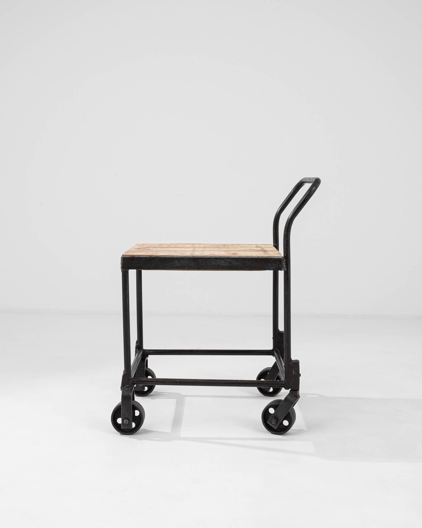 This 20th Century French Metal Bar Cart marries practicality with industrial flair, creating a versatile piece steeped in history. The cart features a sturdy metal frame, exuding the raw elegance of industrial design with its minimalist lines and