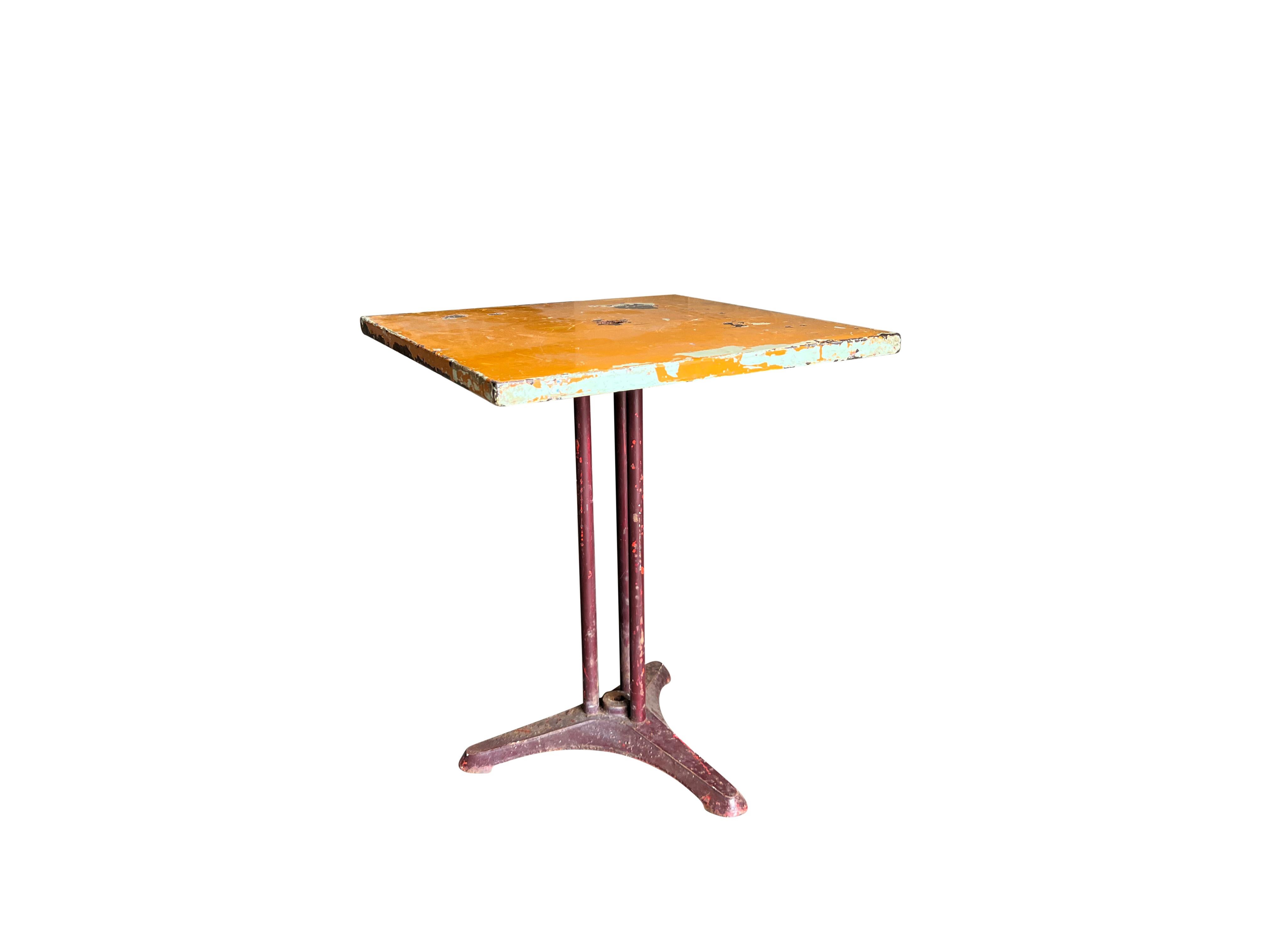 Mesa de bar o bistro parisina francesa vintage con tablero cuadrado de metal y patas de hierro fundido, en buen estado. Pátina original. Pequeña decoloración, arañazos debidos a la edad. Desgaste propio de la edad y el uso. Alrededor de 1950,