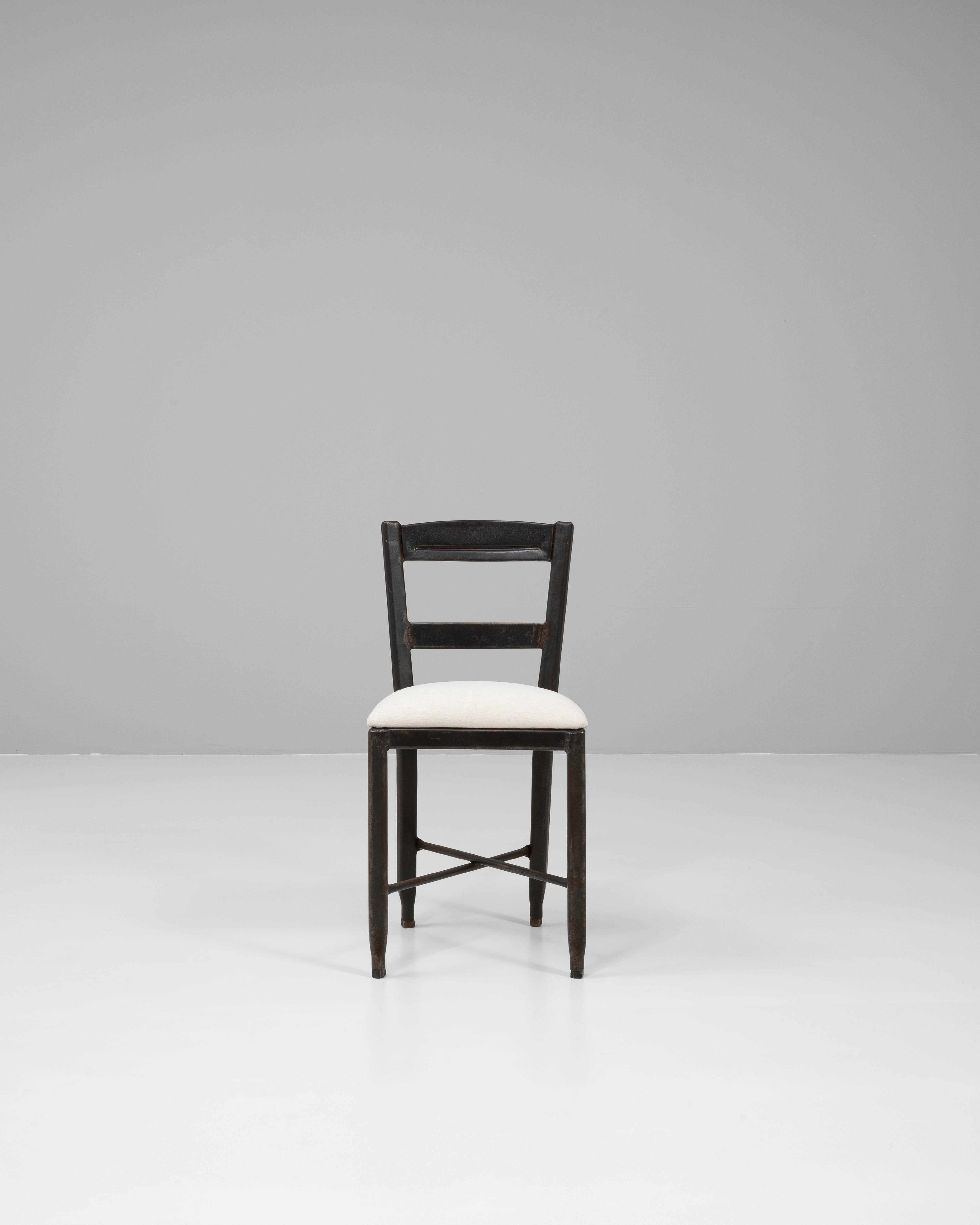 Dieser französische Stuhl aus dem 20. Jahrhundert hat eine minimalistische Silhouette mit dezentem Industriecharme. Der aus Metall gefertigte Rahmen ist mit einer tiefen, abgenutzten Patina überzogen, die seinen Vintage-Charme unterstreicht. Das