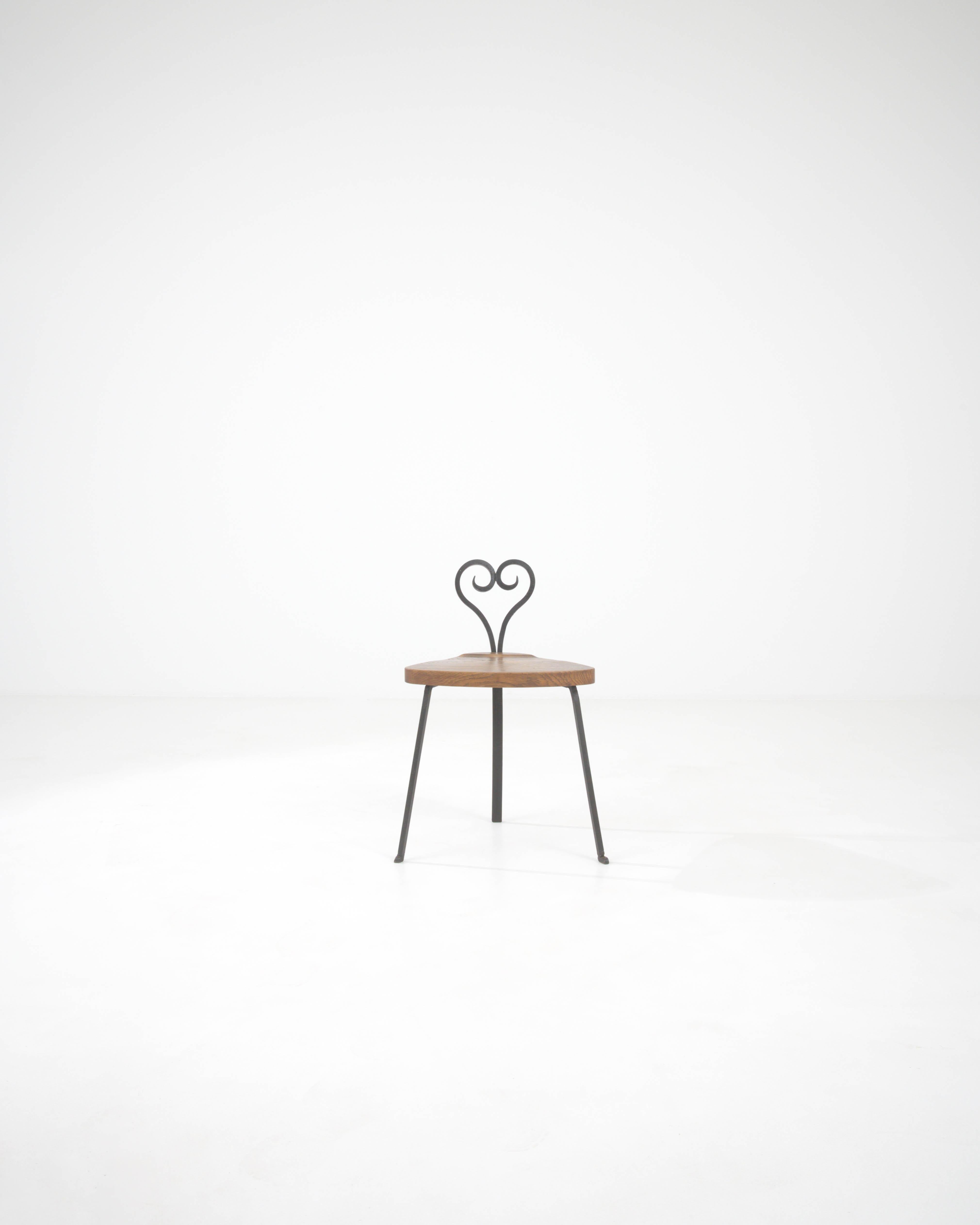 Add a touch of romantic French flair to your decor with this charming 20th-century chair, featuring a sleek metal frame and a warm wooden seat. The standout feature is the whimsically designed backrest with an elegant heart-shaped motif, perfect for