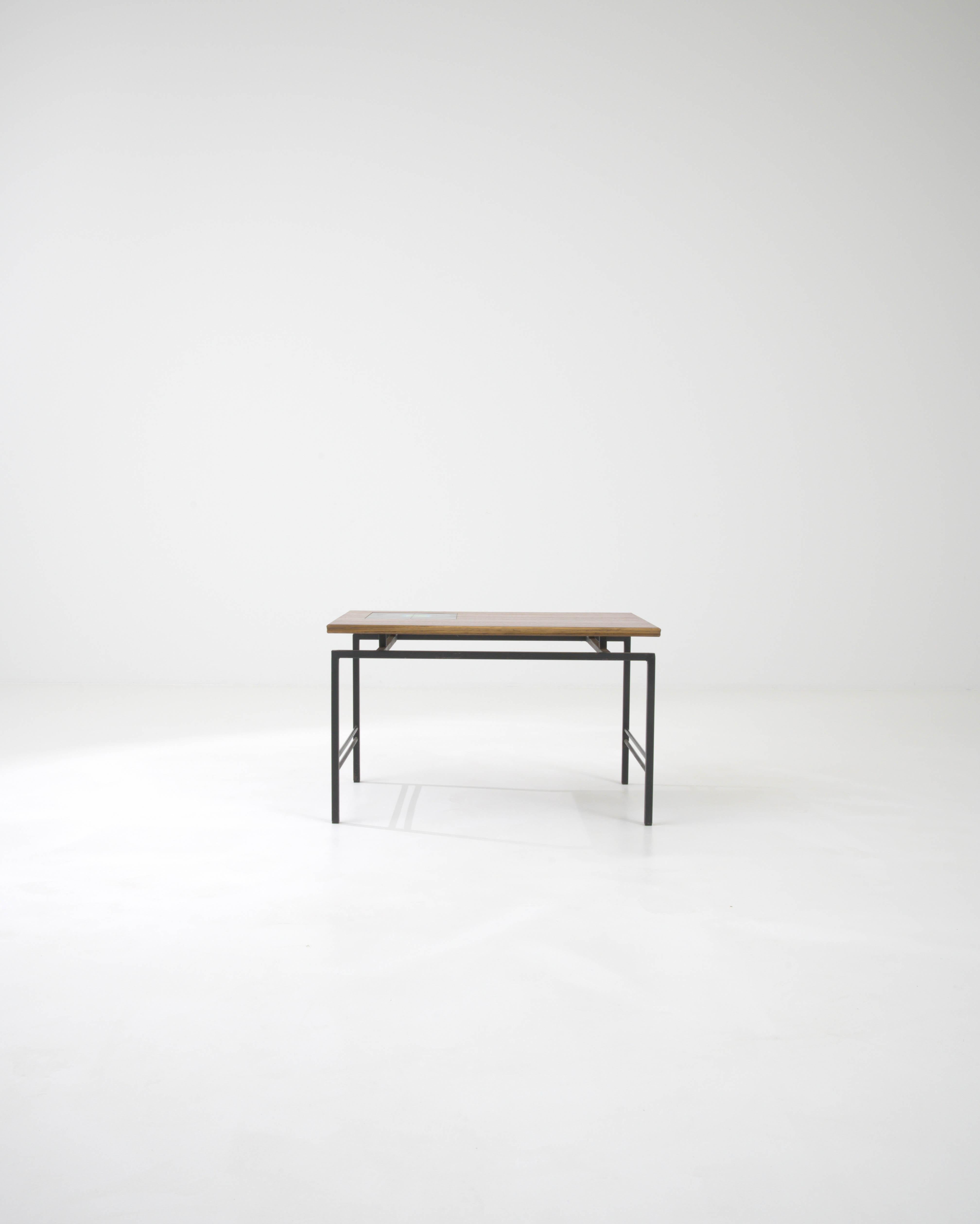 Cette table basse française du XXe siècle marie admirablement la métallurgie épurée à la chaleur organique du bois et à la touche artisanale de la céramique. Le cadre métallique robuste, fini dans un ton mat discret, offre un look industriel moderne
