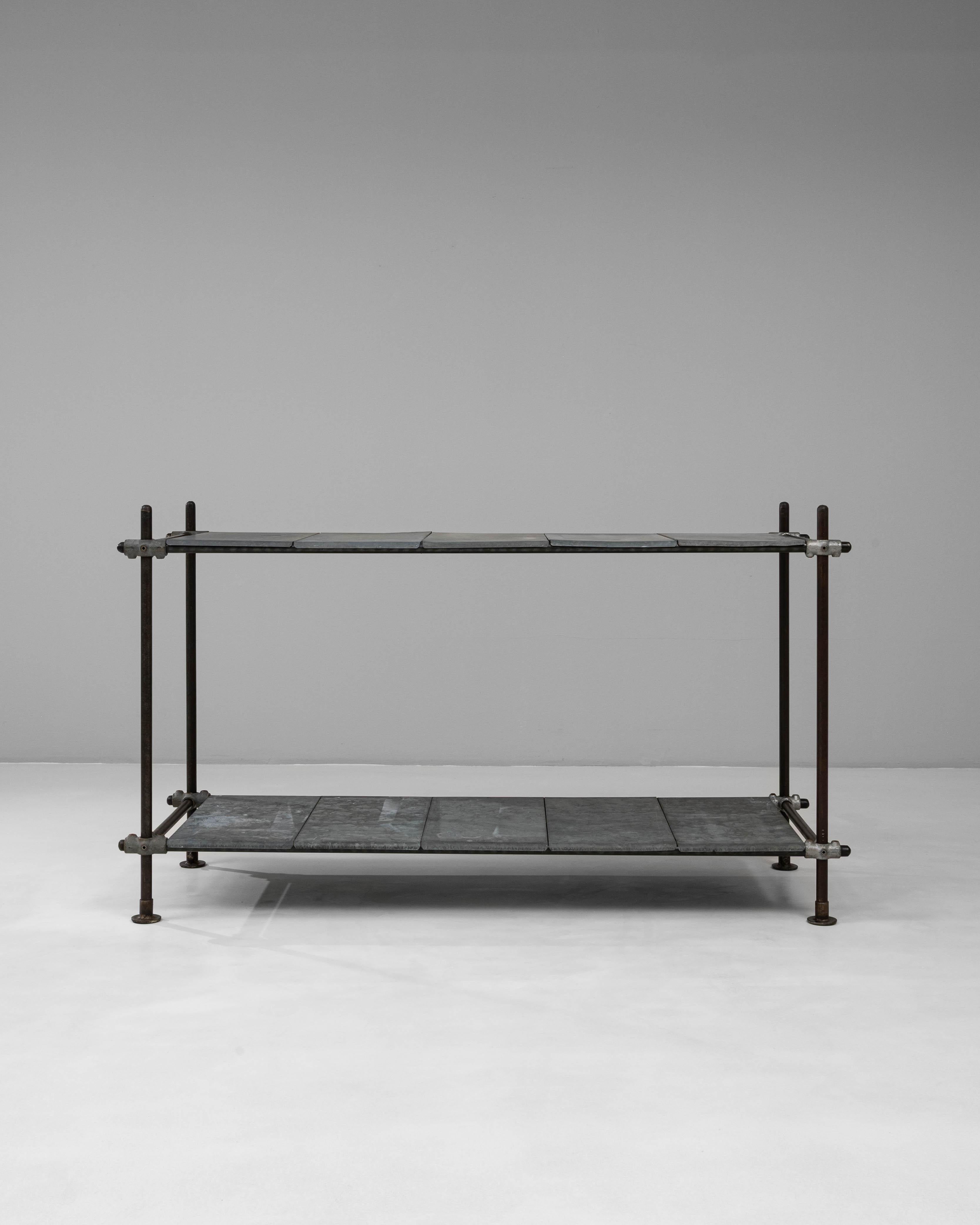 Questa consolle industriale francese del XX secolo presenta un design minimalista e utilitaristico dal carattere grezzo. Realizzato con una robusta struttura in metallo e due ripiani rivestiti in zinco, incarna la raffinata semplicità dei primi