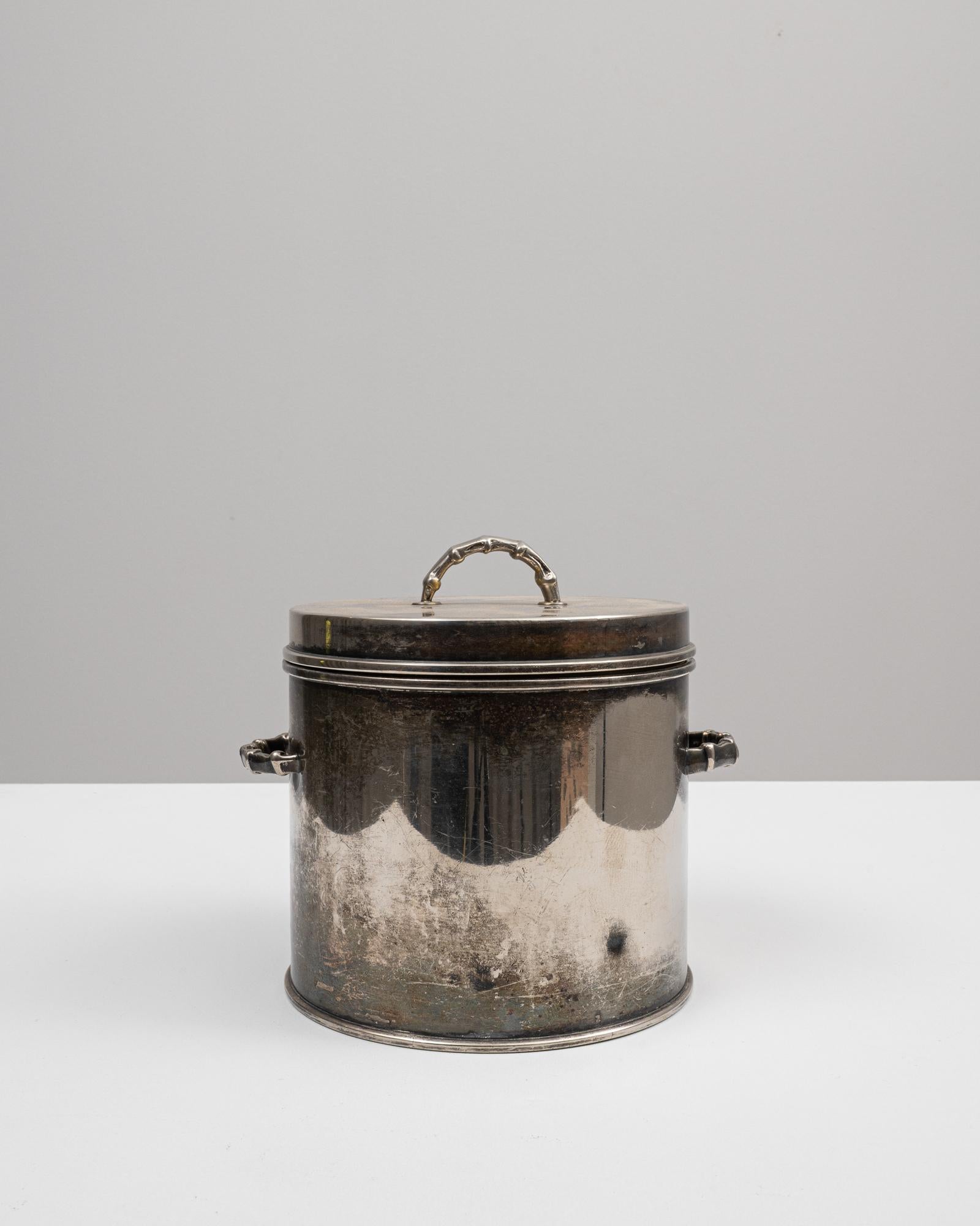 Step back in time with this authentic 20th Century French Metal Pot complete with its original lid, a testament to the durable and functional design of the past. This robust pot, featuring sturdy handles and a secure-fitting lid, is steeped in a