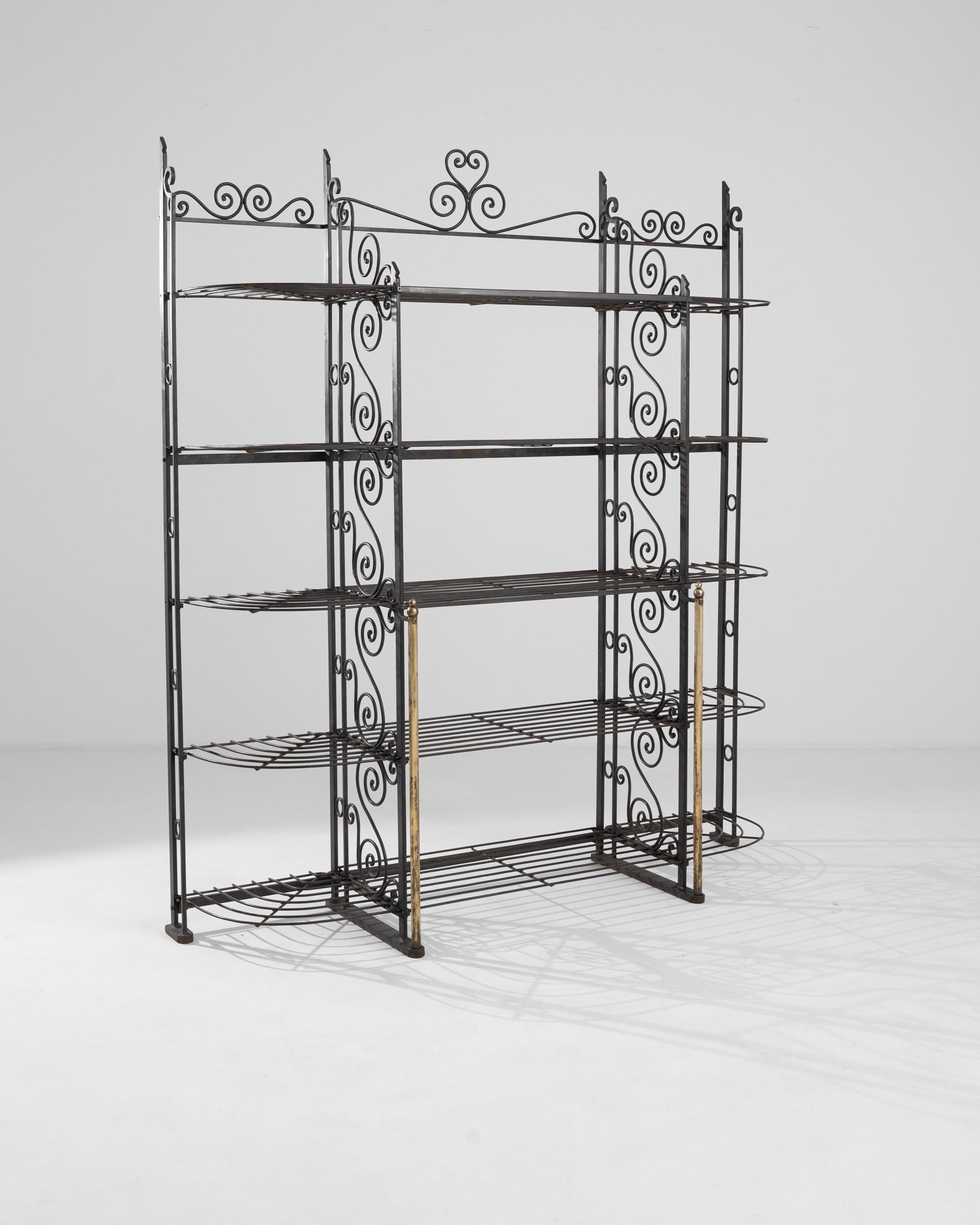 Light and ornate, this set of vintage iron shelves combines practicality with decorative charm. Made in France in the 20th century, the intricate pattern of scrolls which dance like vines across the shelf dividers and the top rail creates a