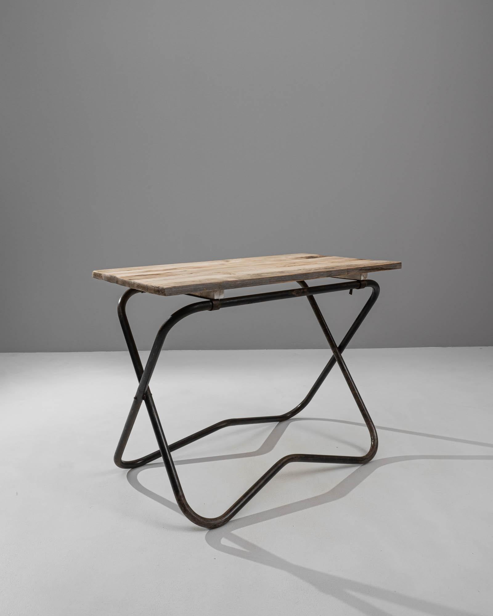 Elevate your space with the understated charm of this 20th-century French Metal Side Table. Featuring a natural wooden top, the table exudes warmth and simplicity. The intersecting dark metal legs not only provide stability but also add a touch of