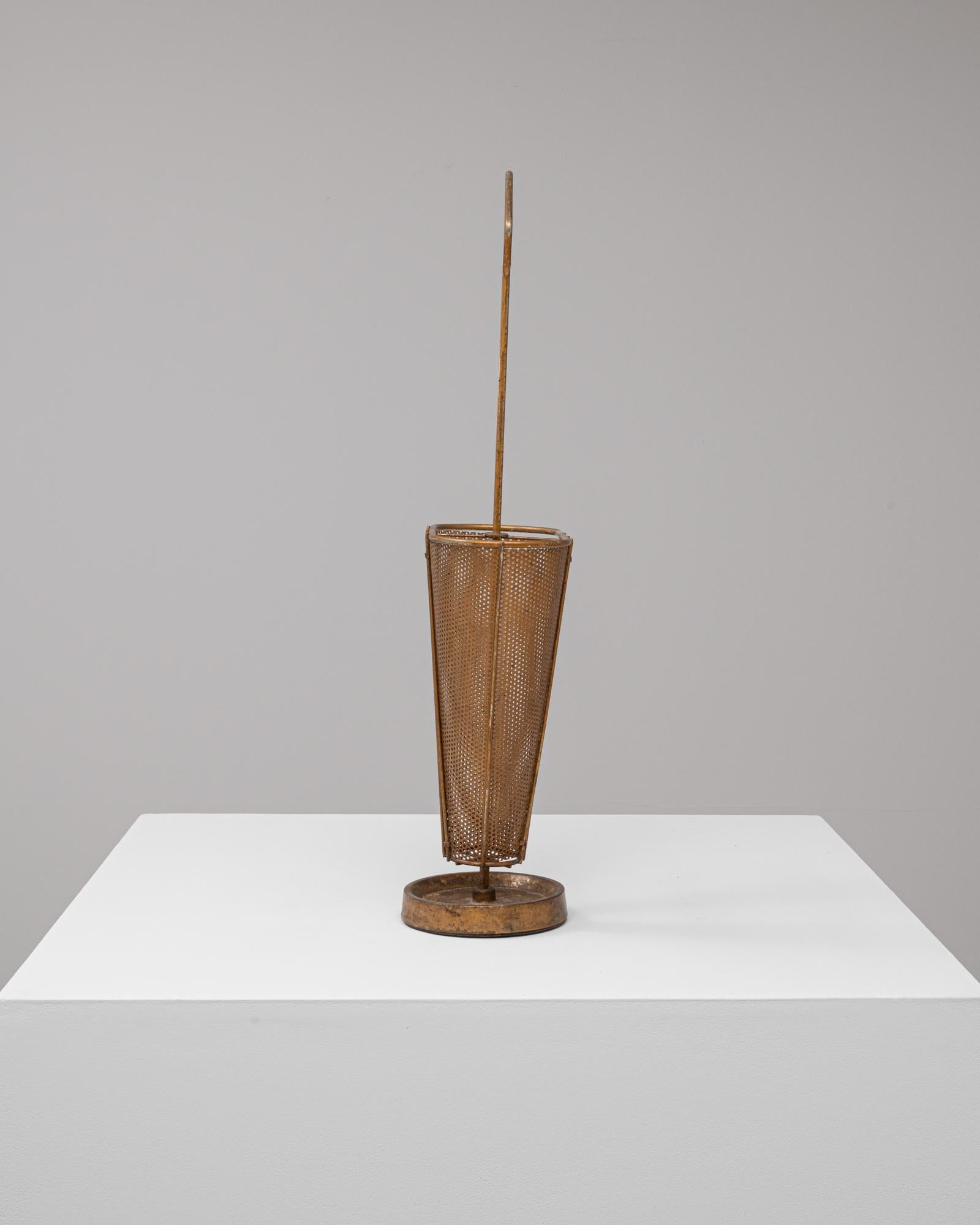 Questo portaombrelli in metallo francese del XX secolo presenta un caratteristico design traforato che unisce funzionalità e fascino industriale. Formata da pannelli conici di metallo punzonato, offre un'ampia ventilazione e leggerezza visiva pur