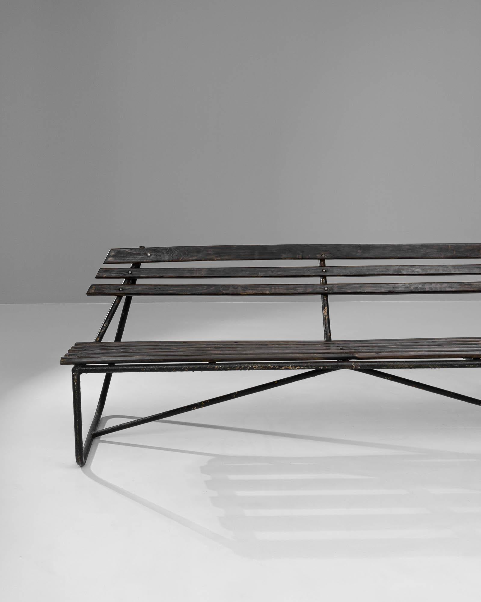 This 20th Century French Metal & Wooden Bench combines the sleek lines of industrial design with the warm, organic feel of wood to create a striking and functional piece of furniture. The bench features a durable metal frame with an angular,