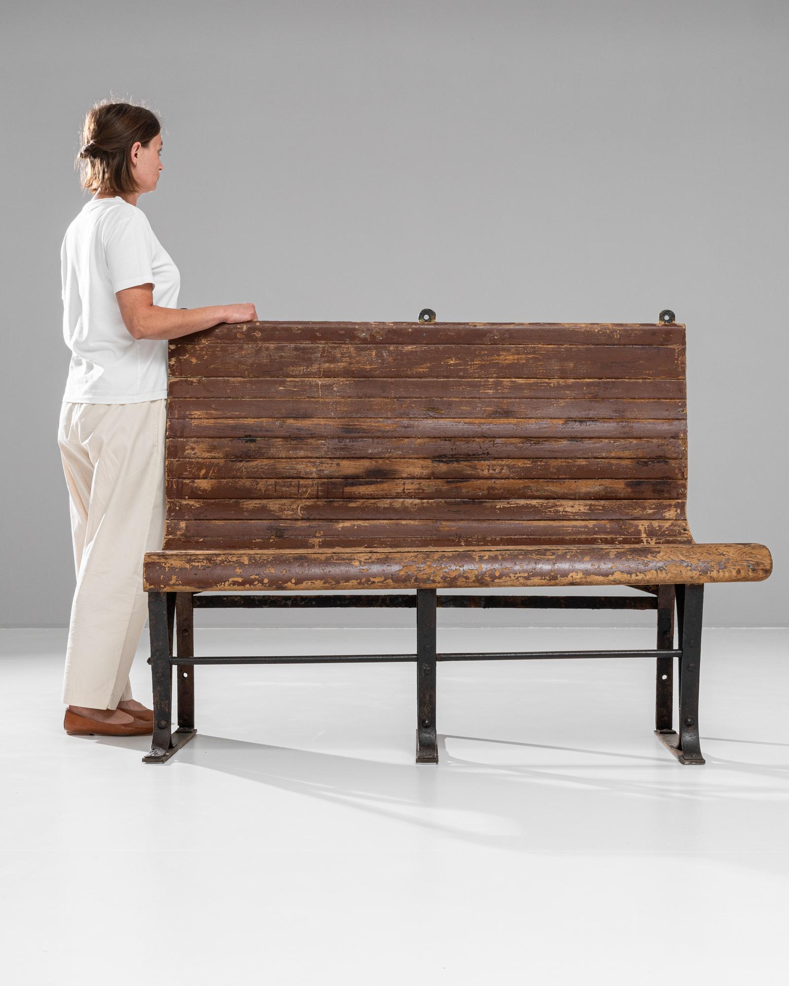 Questa panca francese del XX secolo combina la robustezza industriale con il fascino rustico, mostrando un design che affonda le sue radici nella praticità e nell'eleganza. La seduta e lo schienale sono composti da doghe di legno ben stagionato che