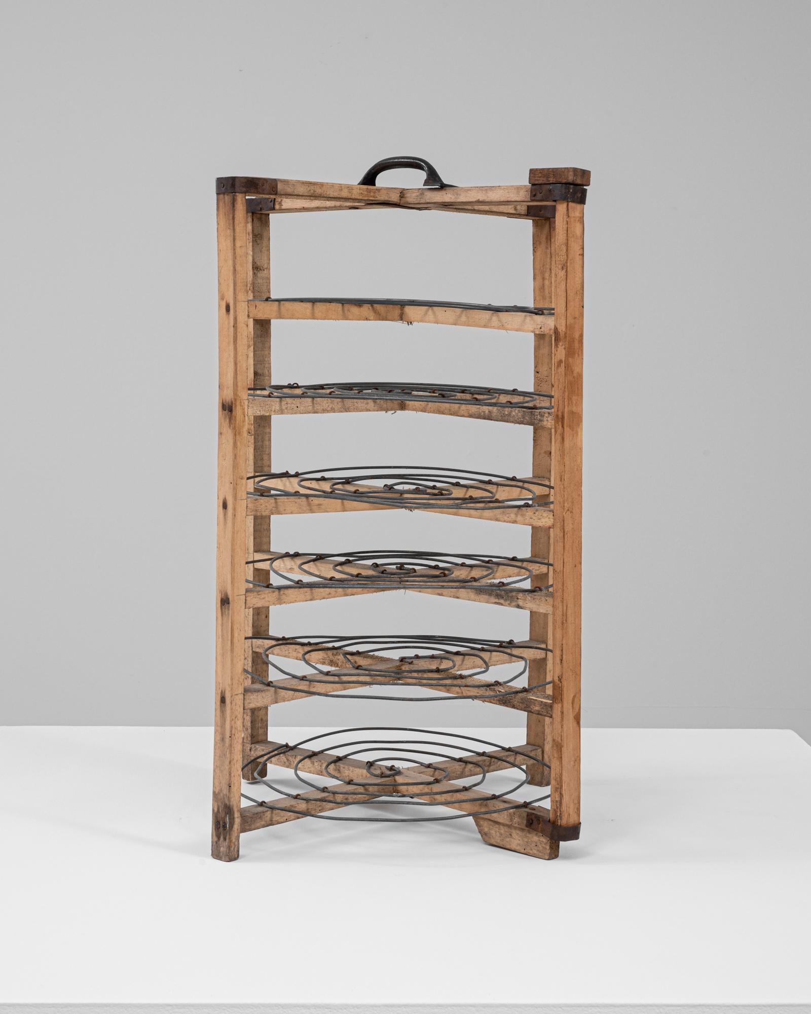 Ce présentoir à gâteaux français du XXe siècle en métal et en bois est une pièce charmante de l'histoire de la pâtisserie, alliant fonctionnalité et élégance rustique. Fabriqué avec un cadre en bois robuste et des supports circulaires en fer forgé,