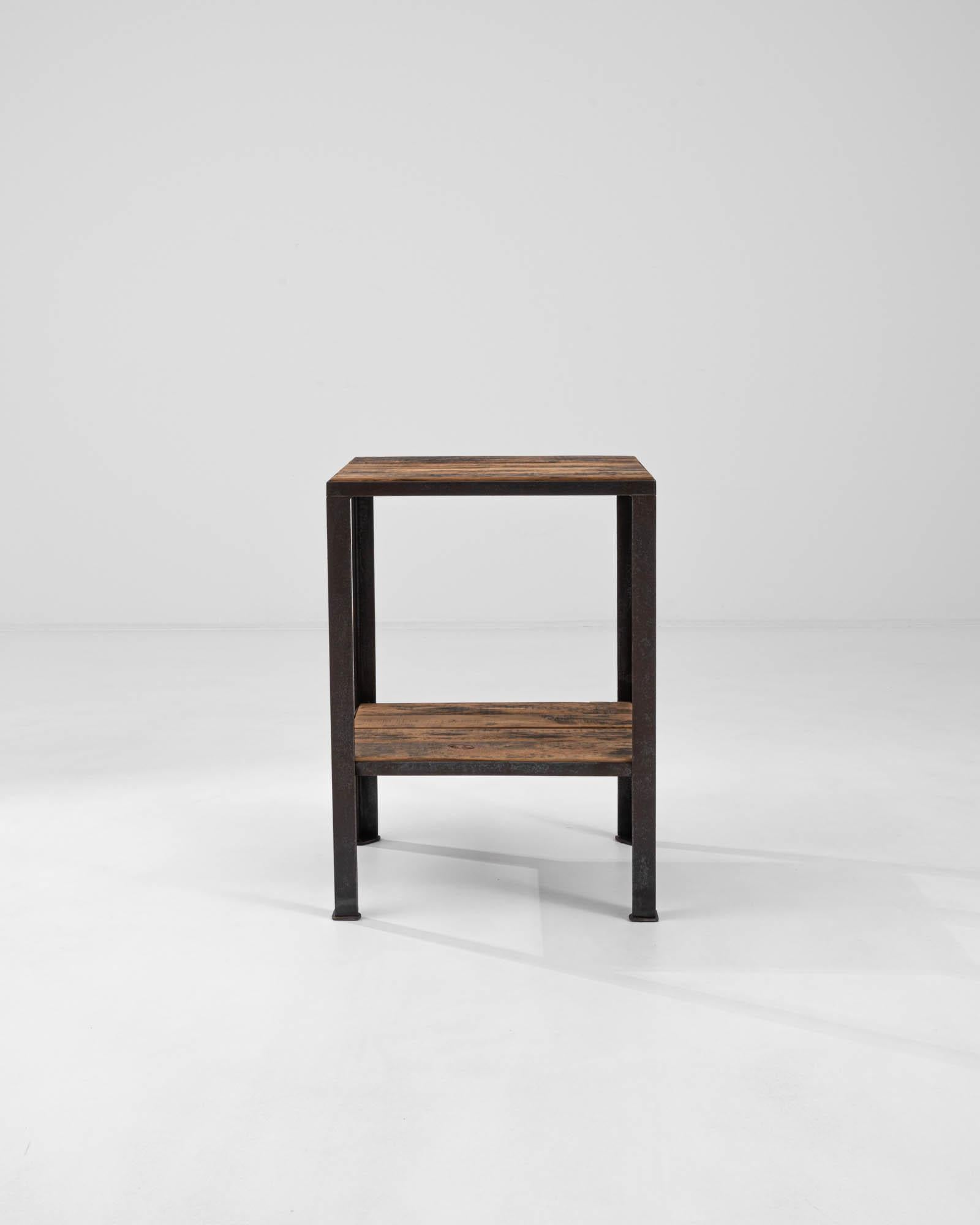 Presenting a harmonious blend of form and function, this 20th Century French Metal & Wooden Side Table exudes a minimalist charm that's both rustic and refined. Crafted with the durability of time-tested materials, it features a sleek, dark metal