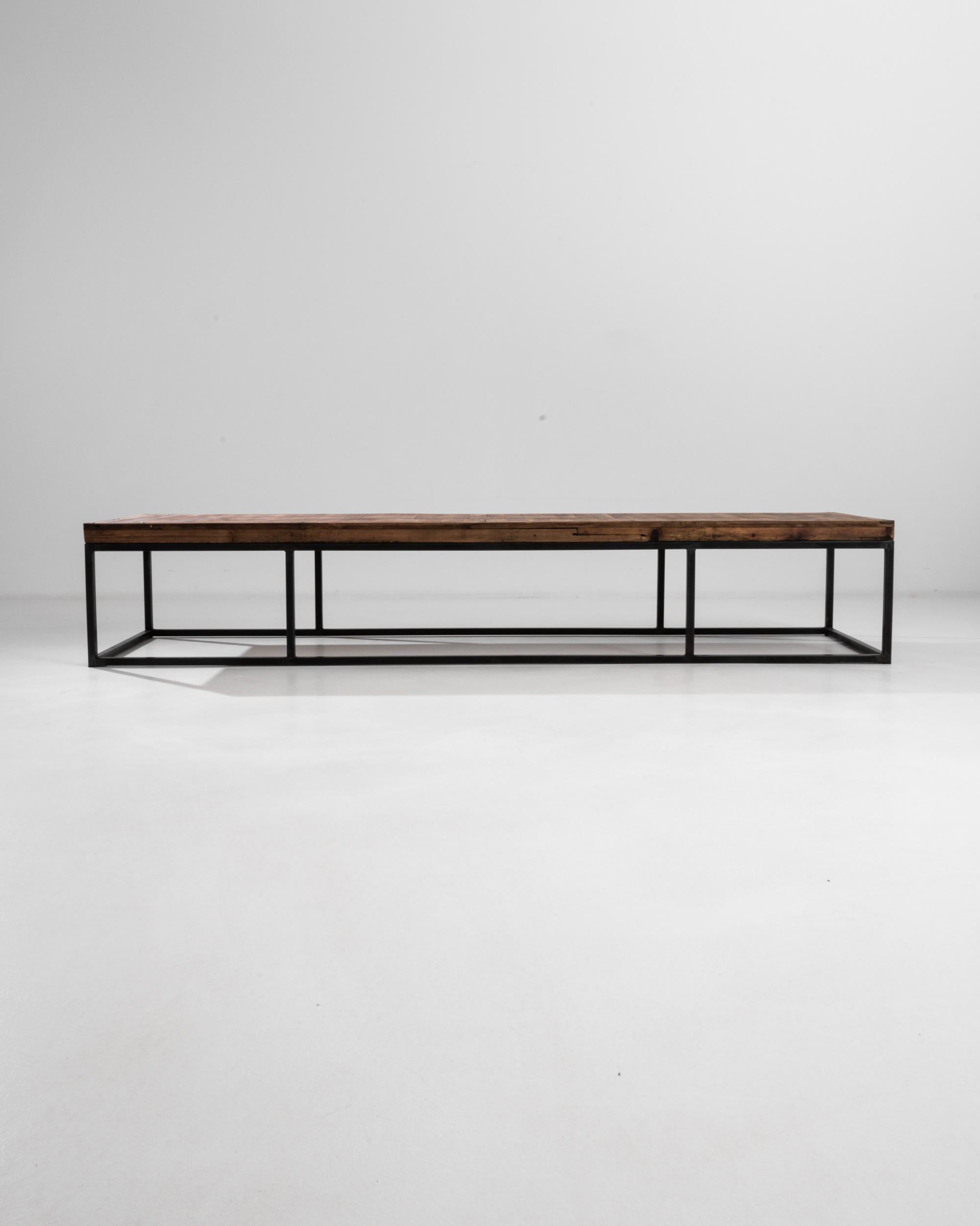 This minimalist coffee table presents an alluring geometry, its steel base divided into three parts make a balanced interplay of solids and voids. The unique length of the table provides an avant-garde profile, while the raw wood finish of the