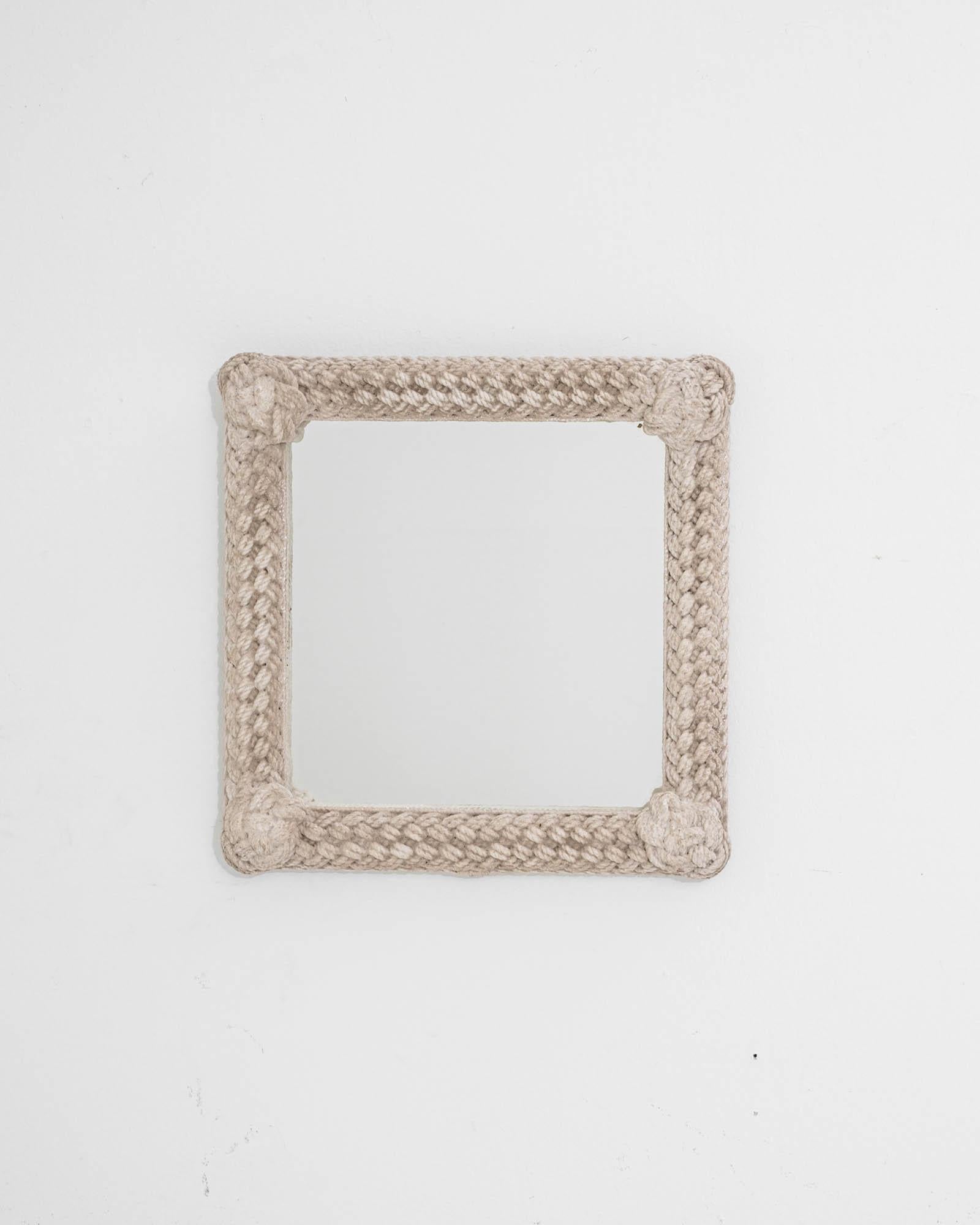 A wooden mirror created in 20th Century France. A truly dazzling work of art, this exquisite mirror exudes a sense of humble regality, articulated effortlessly with a unique motif. The frame of this mirror has been rendered as knotted rope, which