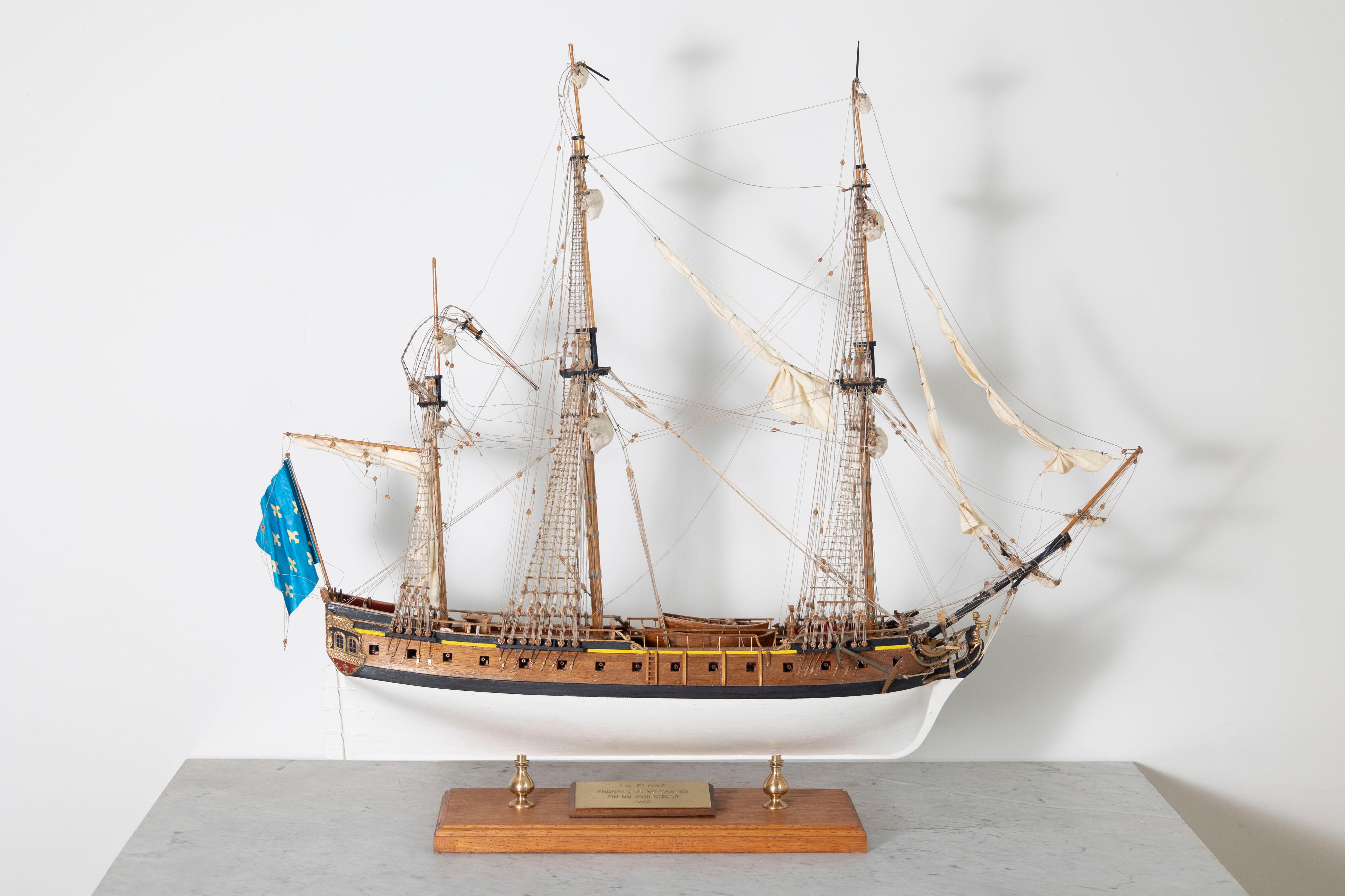 This exquisite 20th Century French model boat beautifully captures the elegance and intricacy of traditional French maritime craftsmanship. Carefully handcrafted from fine wood, this model features detailed rigging, hand-painted accents, and metal