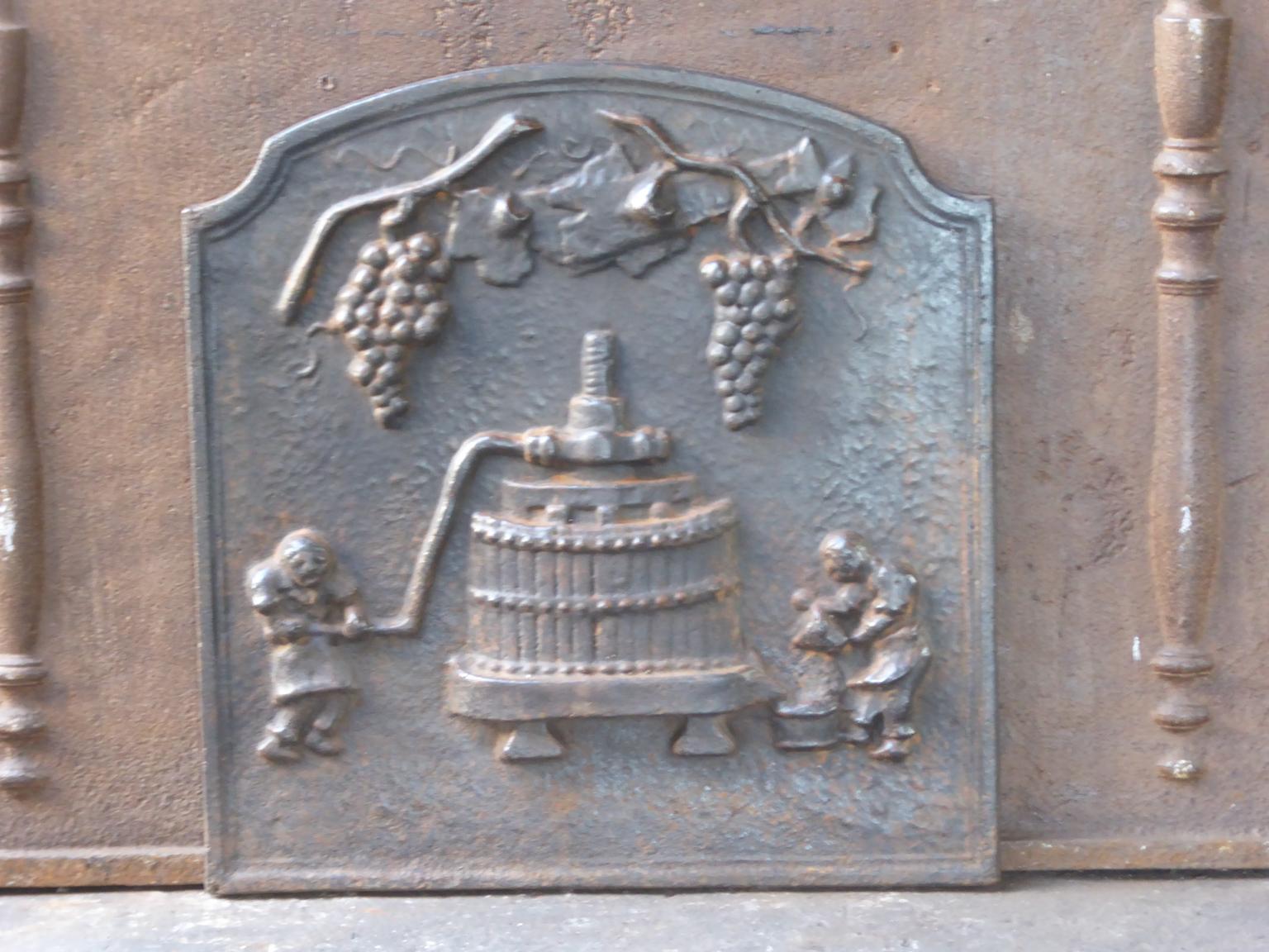 20th century French modernist fireback with vines with grapes and a winery in action. 

The fireback is made of cast iron and has a natural brown patina. Upon request it can be made black. It is in a good condition, without cracks.