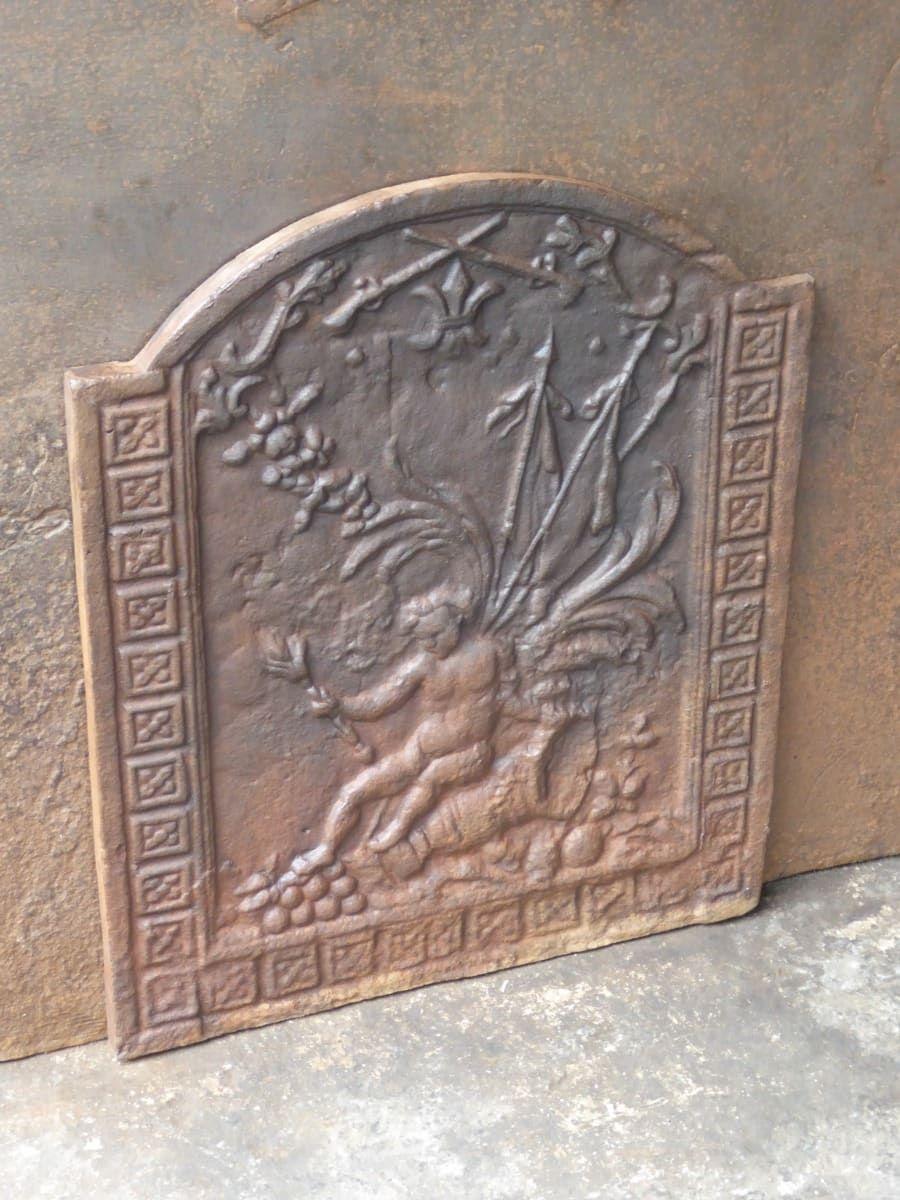 20th Century Napoleon III Style fireback with an unknown theme. 

The fireback is made of cast iron and has a natural brown patina. Upon request it can be made black / pewter at no extra cost. It is in a good condition and does not have cracks.