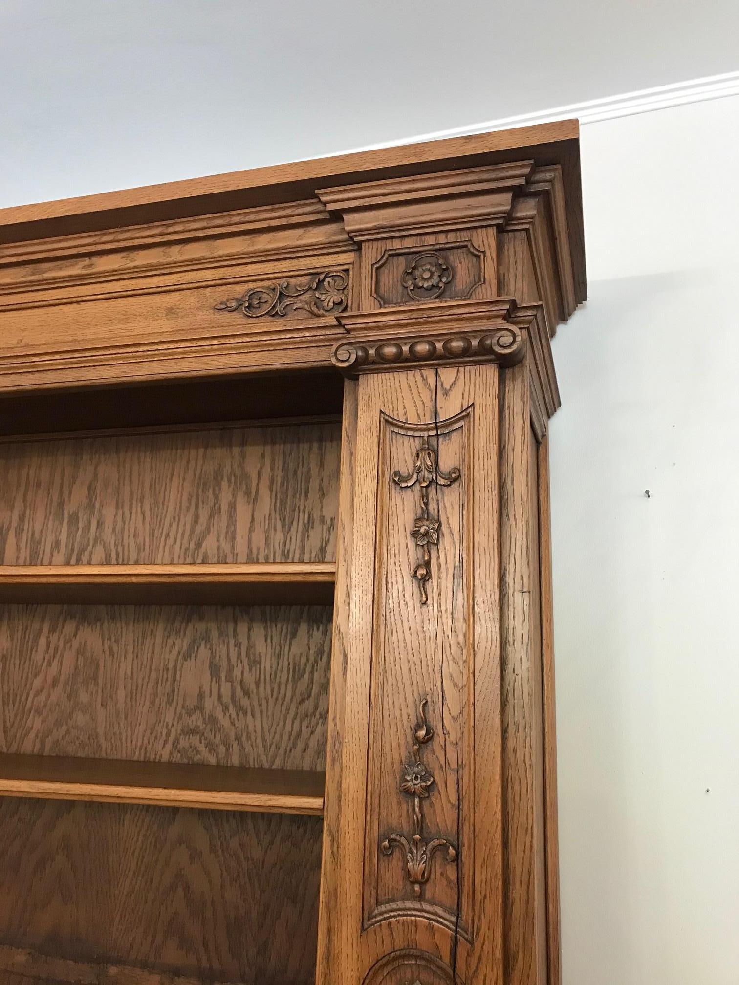 Beautiful and rare 20th century French oak bibliotheque cabinet from the 1920s with large shelves, three doors, three drawers with leaning doors on the top. 
Very nice hand carved wood details. Removable shelves and adjustable as you wish. 
This