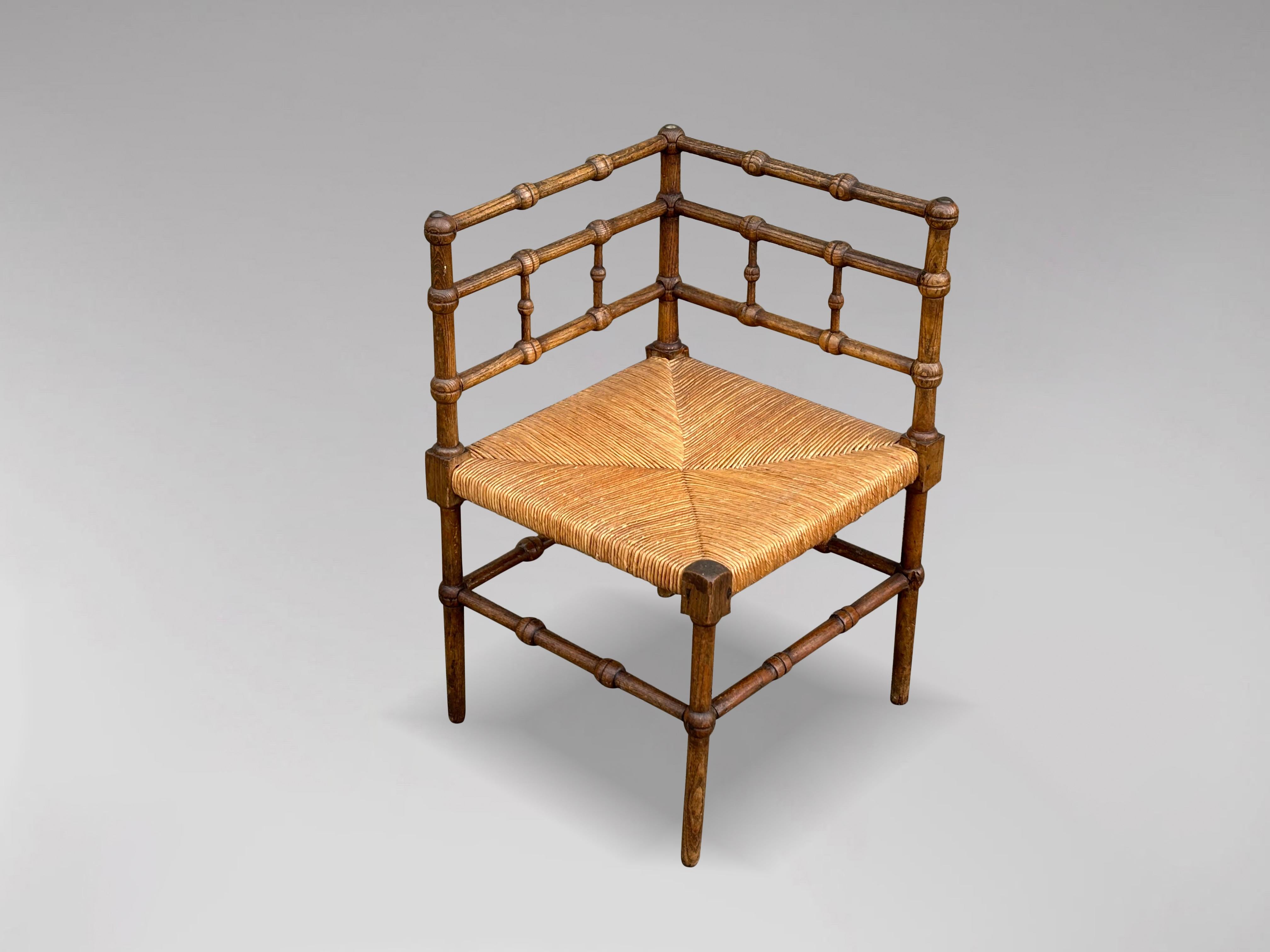 A charming early 20th-century French provincial bobbin wood corner chair. It features beautifully turned oak frames with the original striped rush seats. Sourced from the south of France, it is in very good antique condition. This stylish,