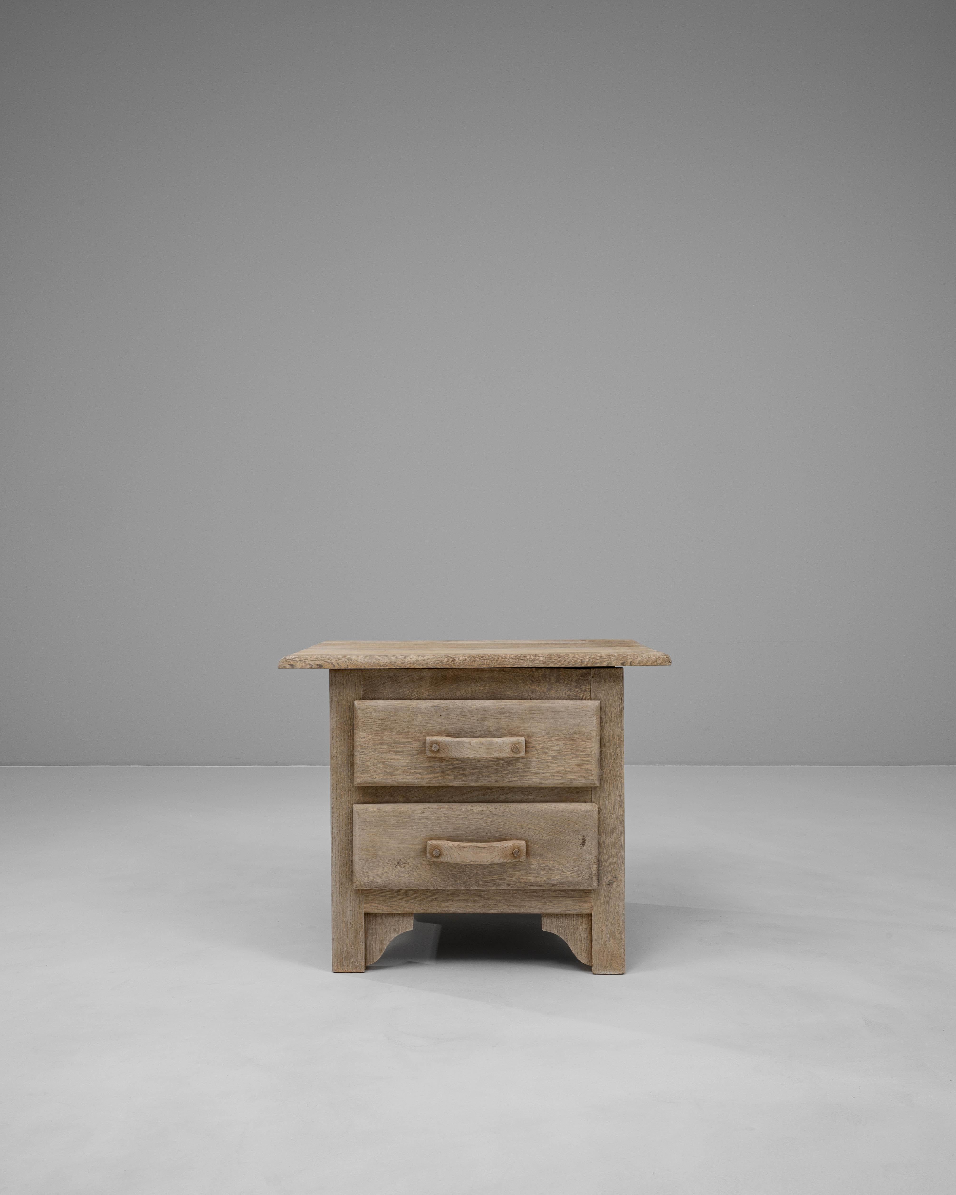 Cassettiera in rovere francese del XX secolo con una solida struttura realizzata a mano con due cassetti e maniglie in legno scolpite. La morbida finitura in rovere sbiancato esalta la struttura e le venature naturali del legno, conferendogli un