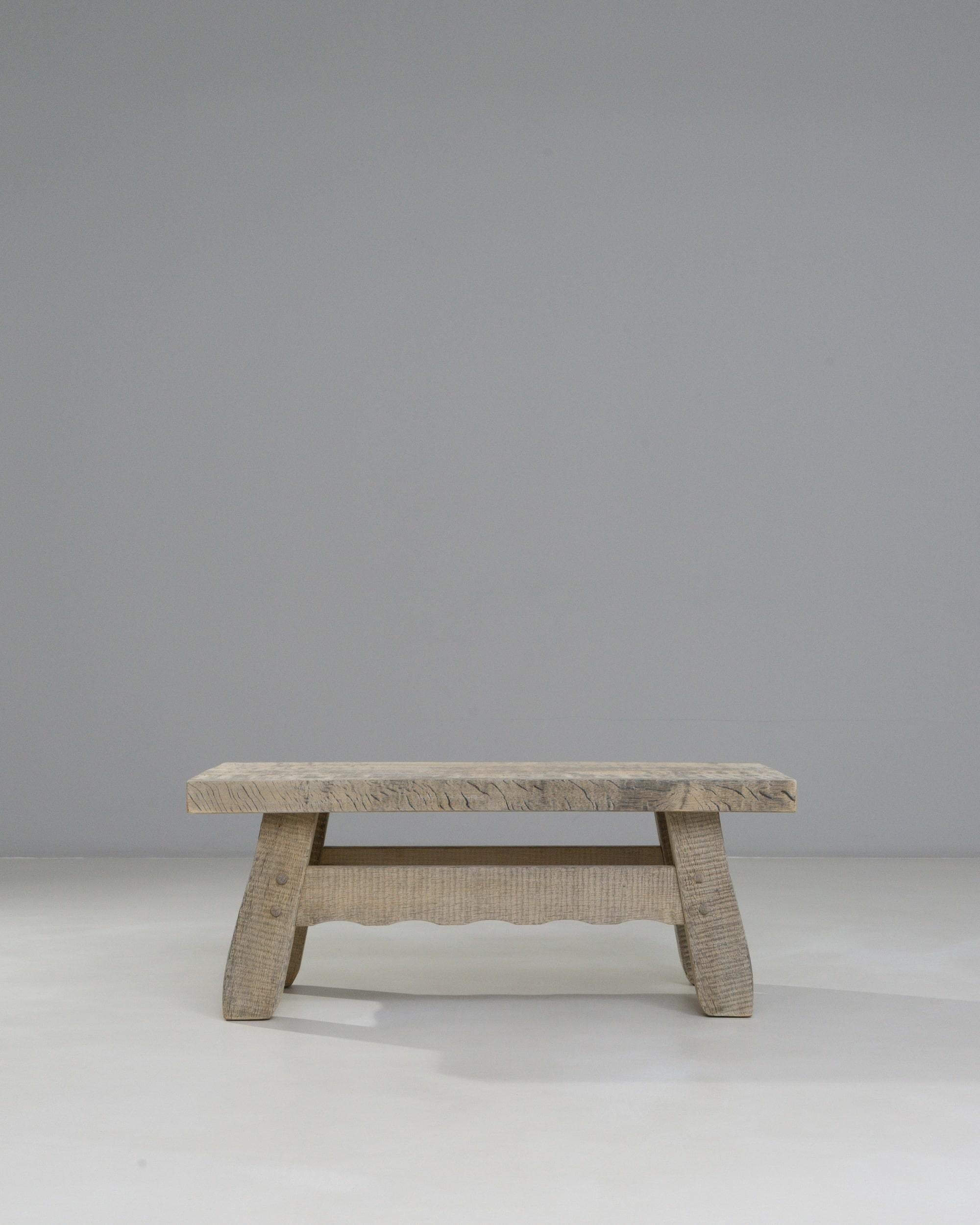 Cette table basse en chêne français du 20e siècle présente un plateau substantiel et une base sculptée qui mettent en valeur le grain expressif et la texture naturelle du chêne vieilli. Les surfaces taillées à la main et les bords doucement arrondis