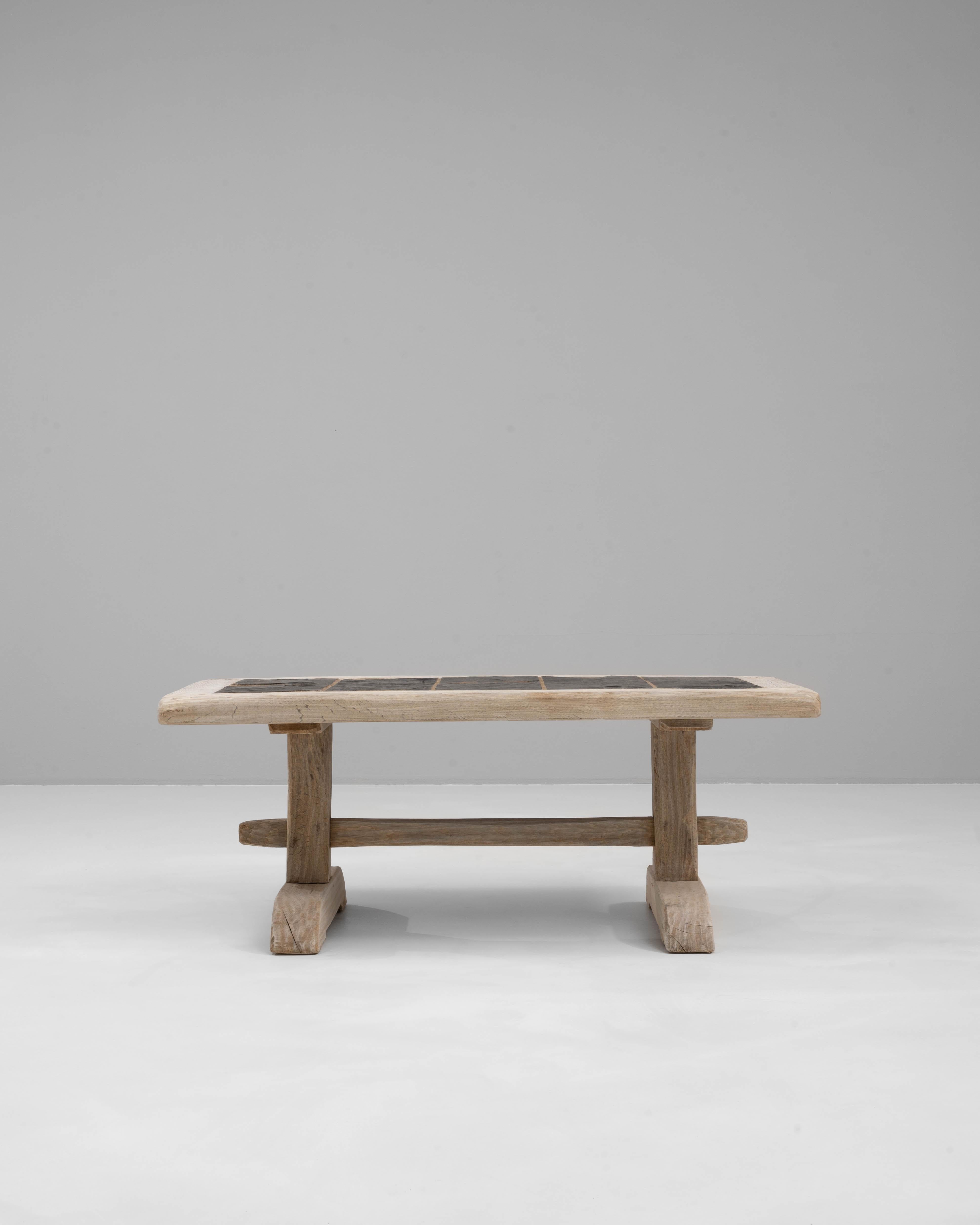 Cette table basse en chêne français du 20e siècle respire l'élégance rustique, alliant un savoir-faire robuste à des matériaux naturels. Le cadre en chêne robuste présente une finition joliment vieillie, mettant en valeur le grain et la texture
