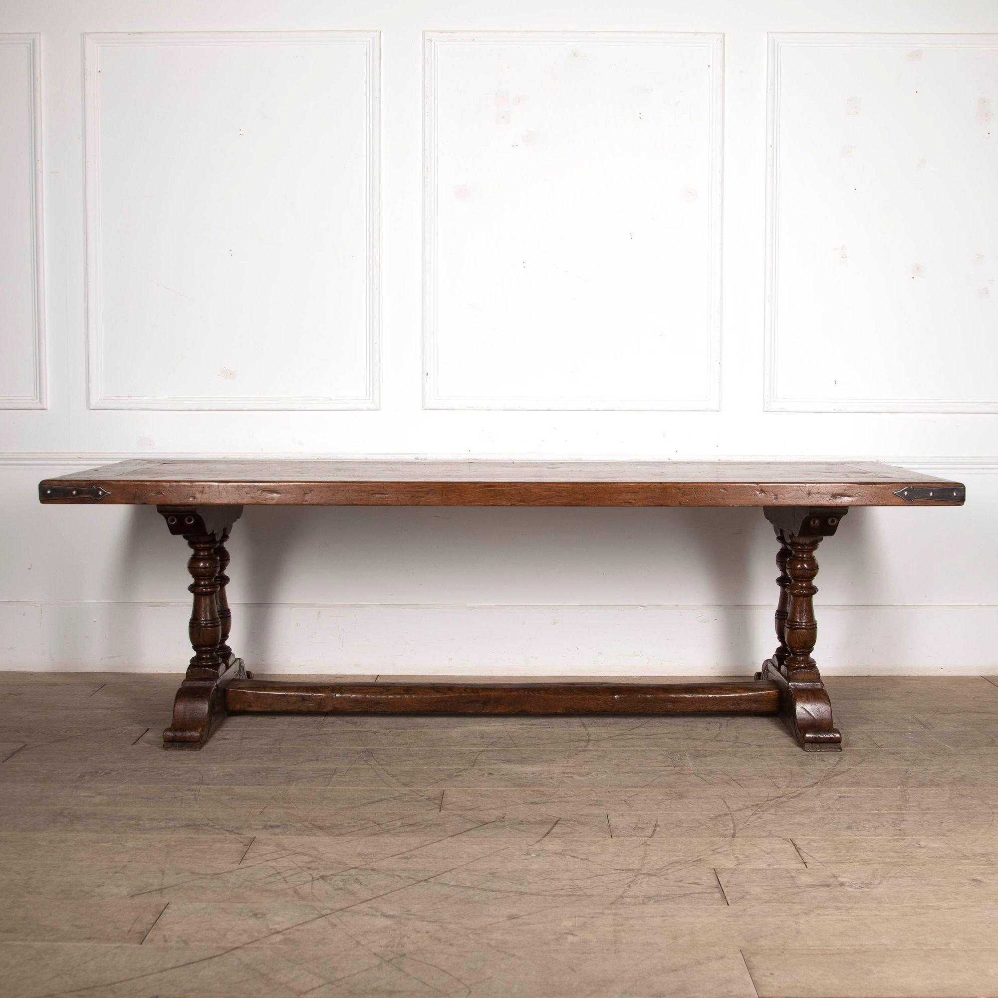 Wonderful 20th century style oak refectory table on twin baluster columns.
With metal banding on the corners, this is a great practical table to sit at.
With the over hang on the ends this table will sit 10 to 12 people.
For ease of delivery the