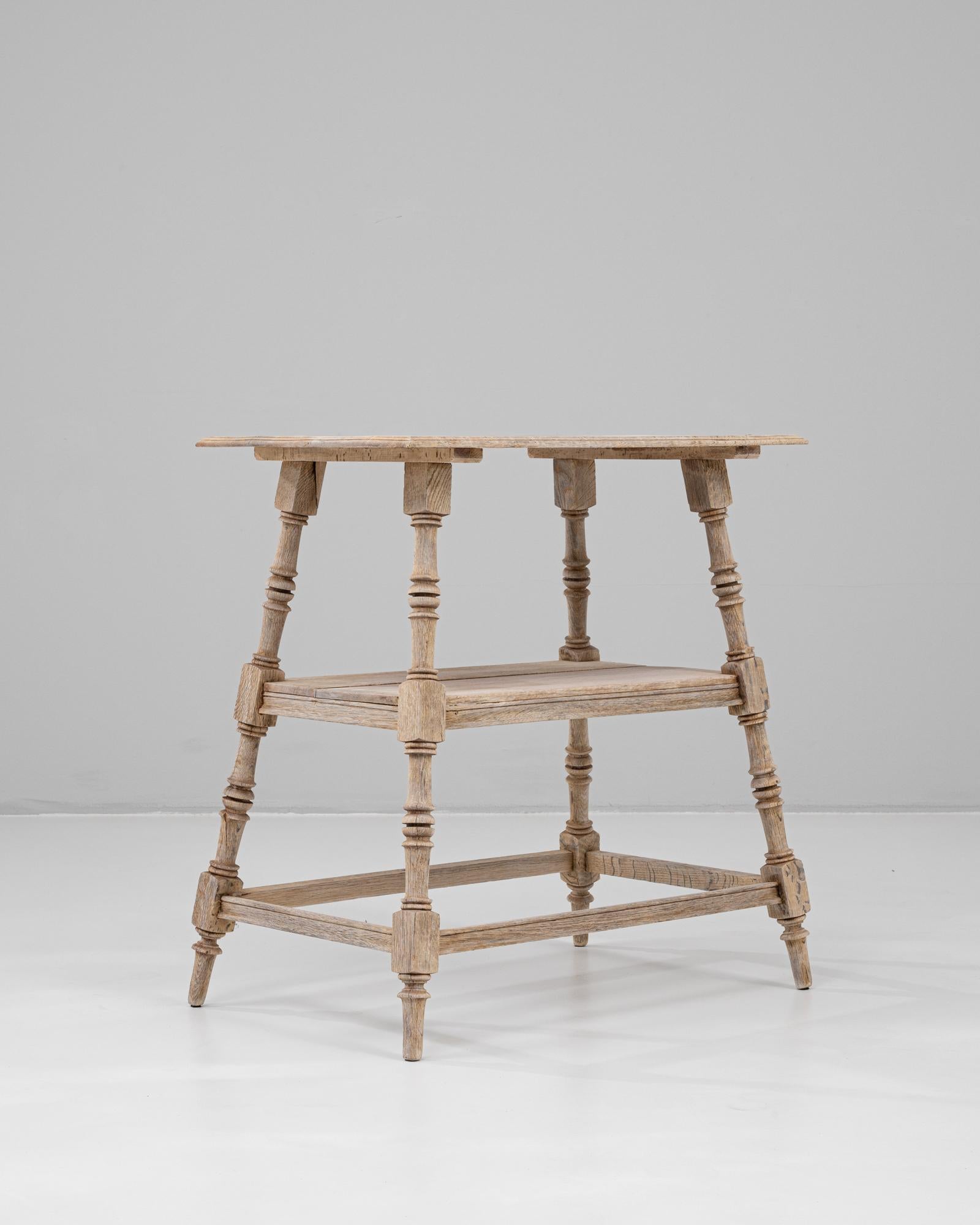 Cette table d'appoint en chêne français du XXe siècle présente une finition joliment patinée et des pieds finement tournés qui soulignent son caractère artisanal classique. Le plateau rectangulaire est soutenu par une structure à deux niveaux, avec