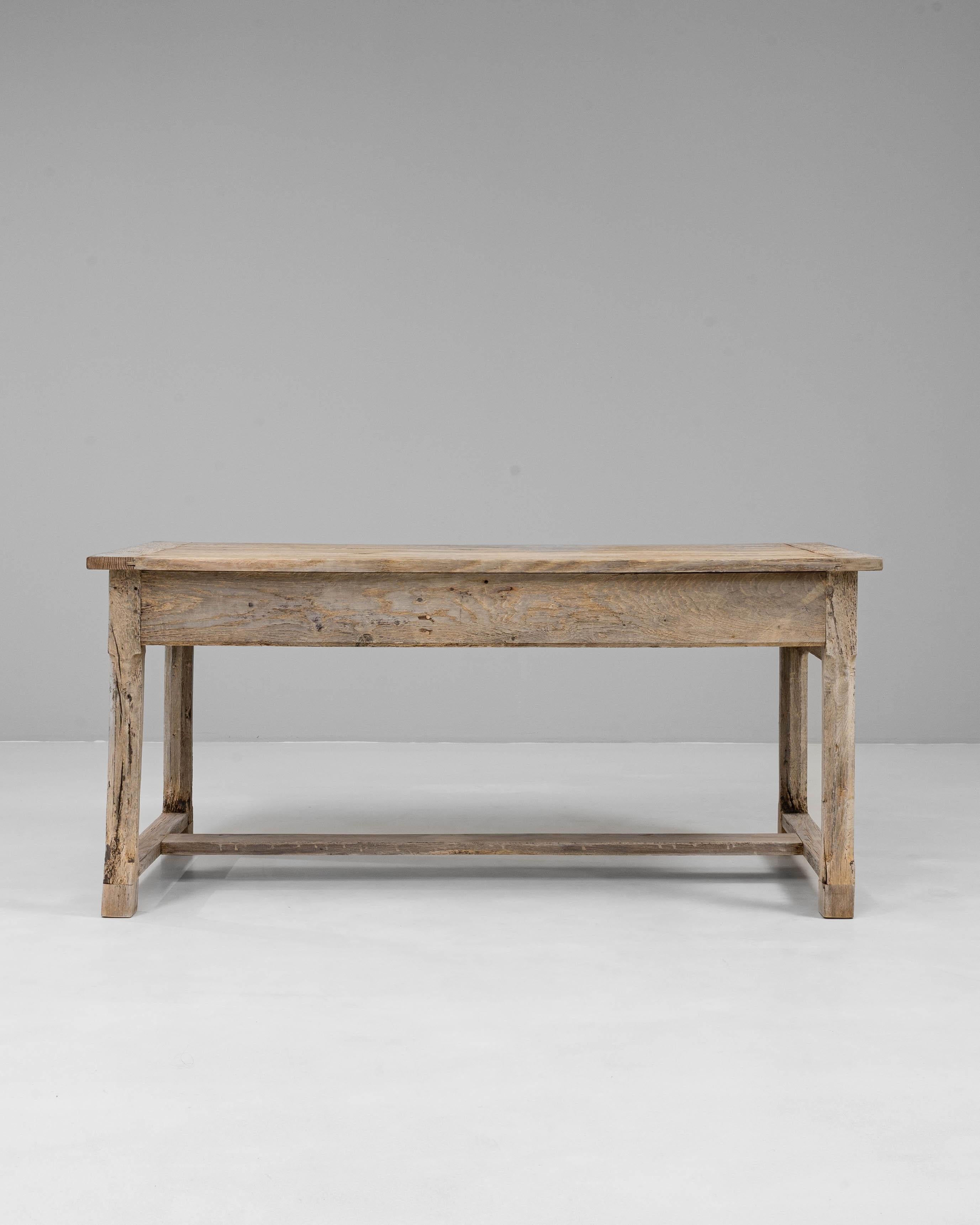 Cette table à manger à tréteaux en chêne français du 20e siècle présente une simplicité rustique et un savoir-faire intemporel. Construite en chêne massif avec une surface joliment patinée, la table présente des lignes épurées, un tiroir latéral