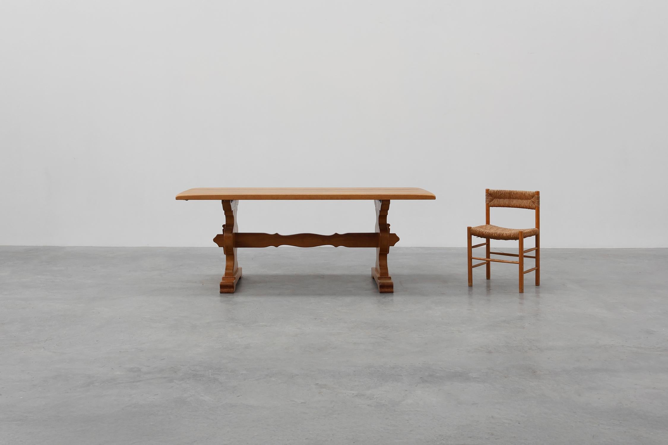 France / 1950 / dining table / oak / Mid-Century / Rustic / French Provincial / Brutalist

Solid oak trestle dining table in the manner of the Danish designer Henning Kjærnulf. 
This exquisite dining table features a sculpted trestle base and