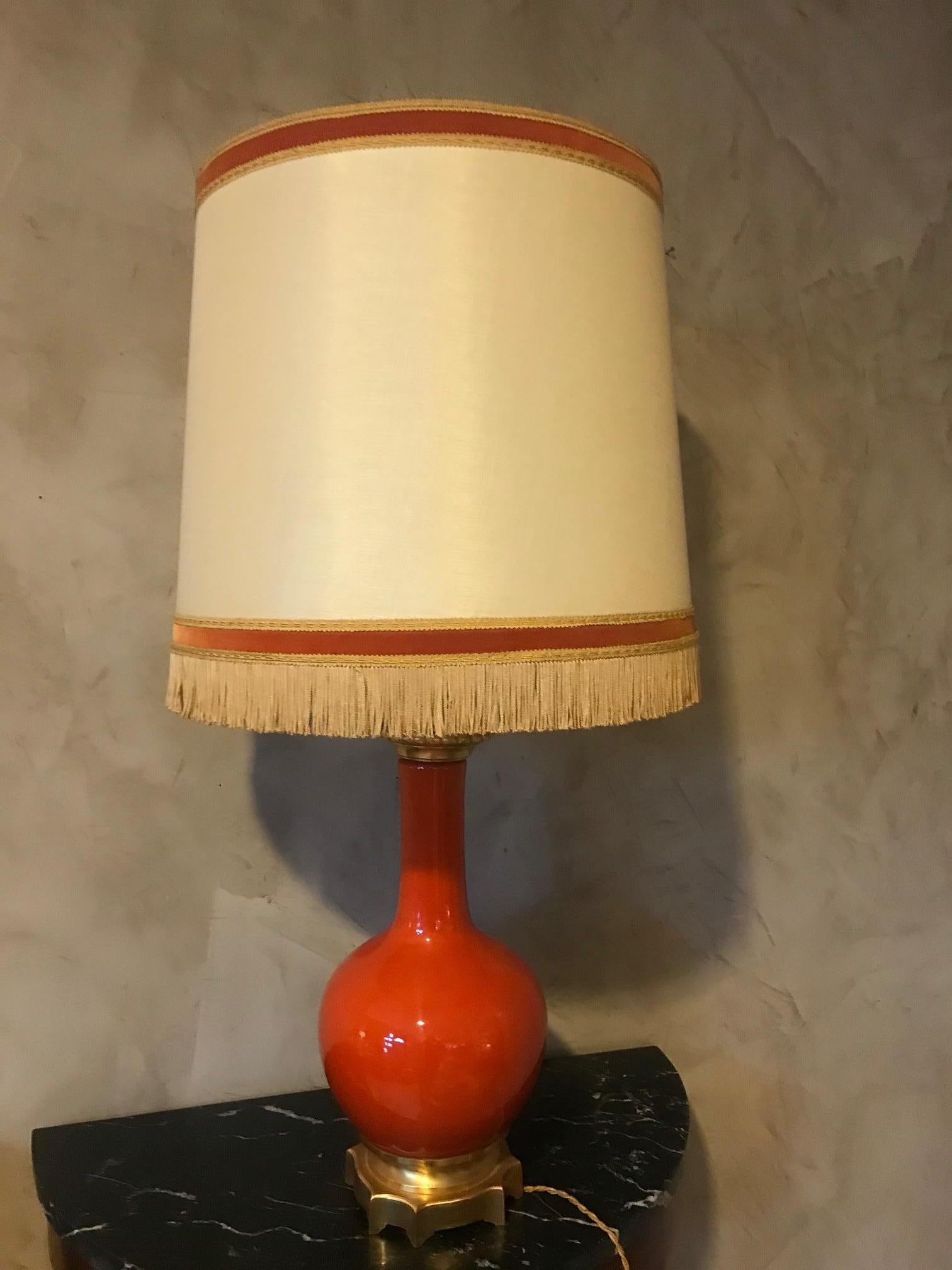 Magnifique lampe de table en verre opalin orange et laiton du 20e siècle, datant des années 1920. 
Bel abat-jour à franges. Base en laiton doré. 
Bonne qualité et bon état.