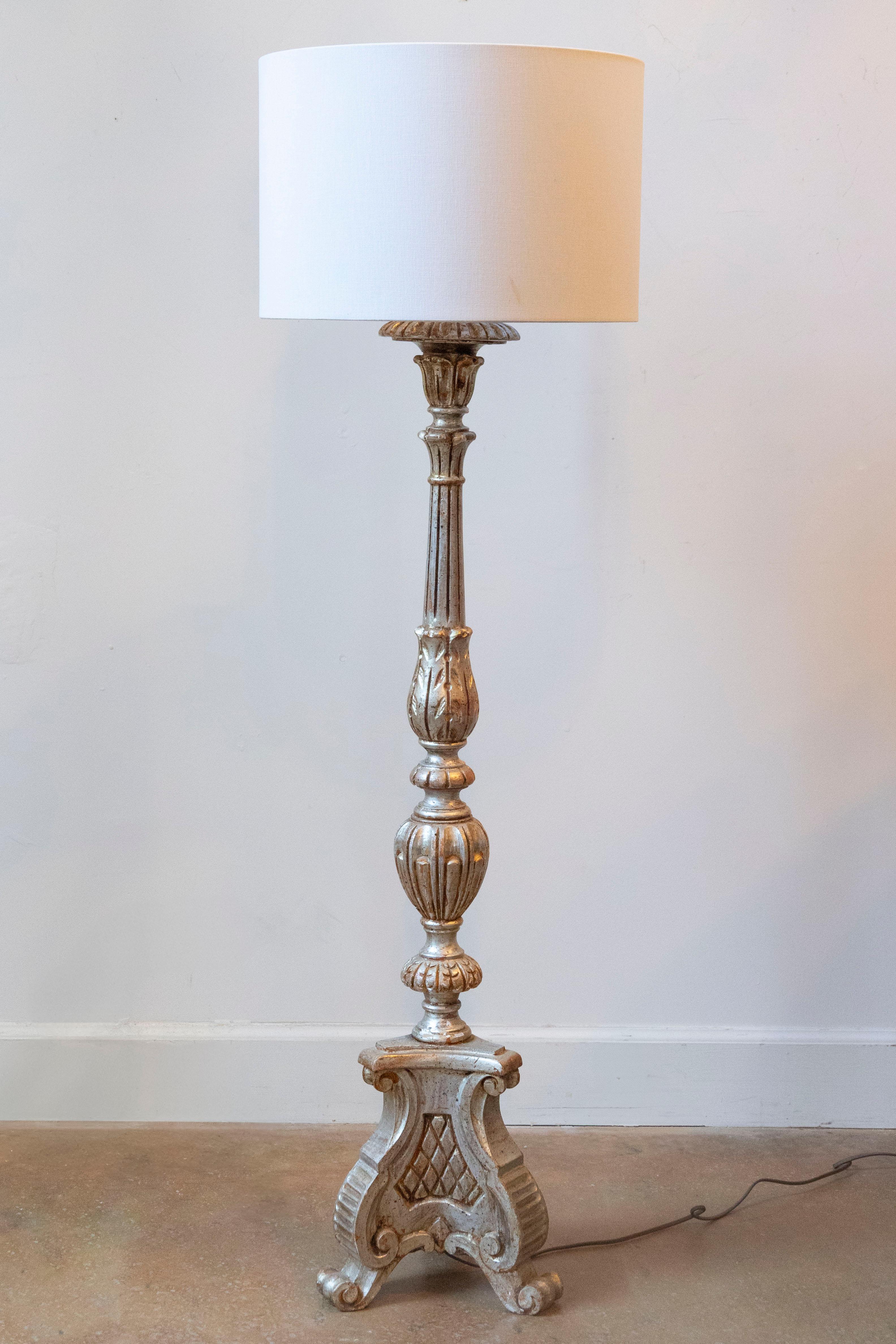 Elegante y rica en texturas, esta lámpara de sobremesa francesa del siglo XX captura el encanto del diseño neoclásico con su forma de madera bellamente tallada y su acabado suave y desgastado por el tiempo. Pintada en un tono marfil apagado con
