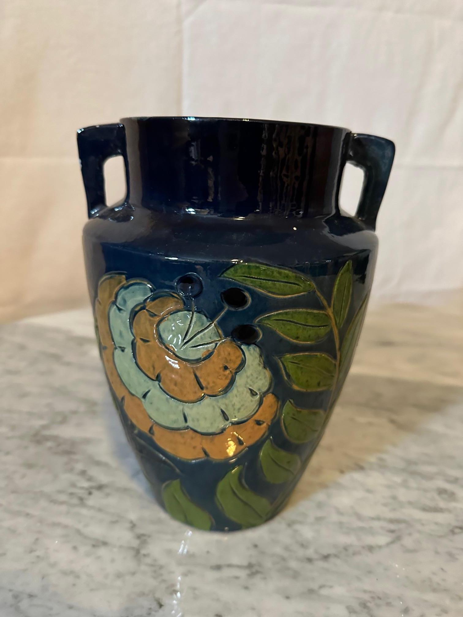 Magnifique vase en terre cuite émaillée datant des années 1940 en bon état avec double poignée. Originaire de Savoie, Fauquet à Bonneville France.  Décoré de fleurs jaunes et de feuillage vert. 
Signé 