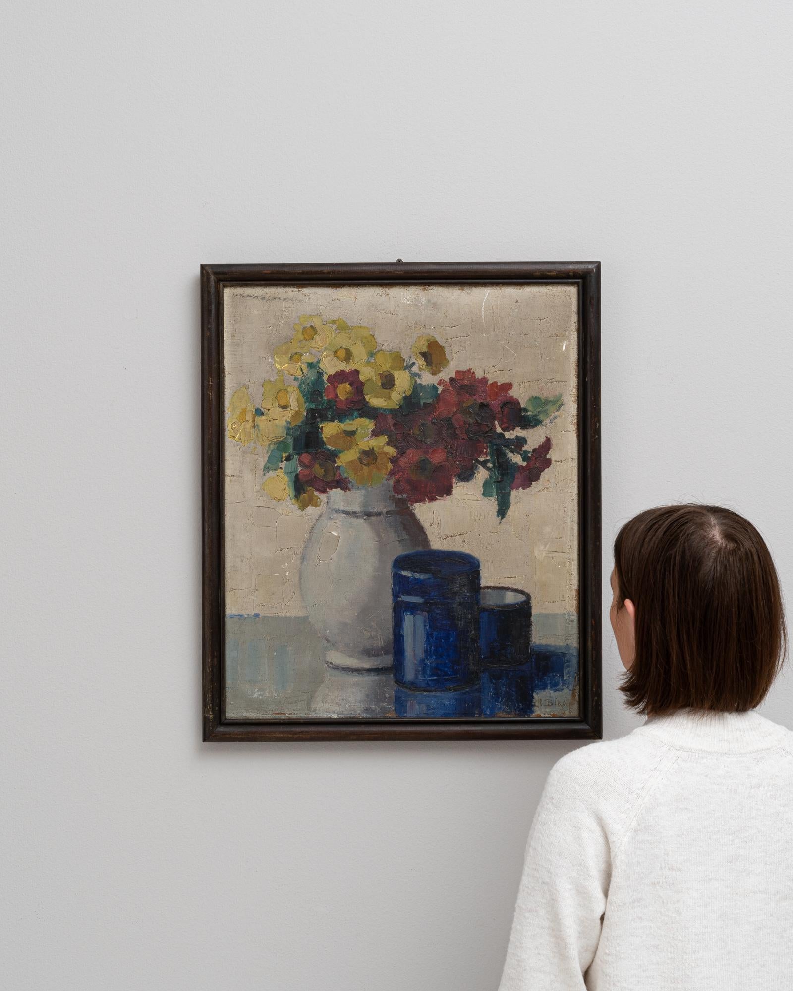 This delightful 20th Century French painting brings a burst of color and charm to any space. It features a vibrant bouquet of flowers, rendered in thick, confident brushstrokes, set against a muted background that allows the warm yellows and deep