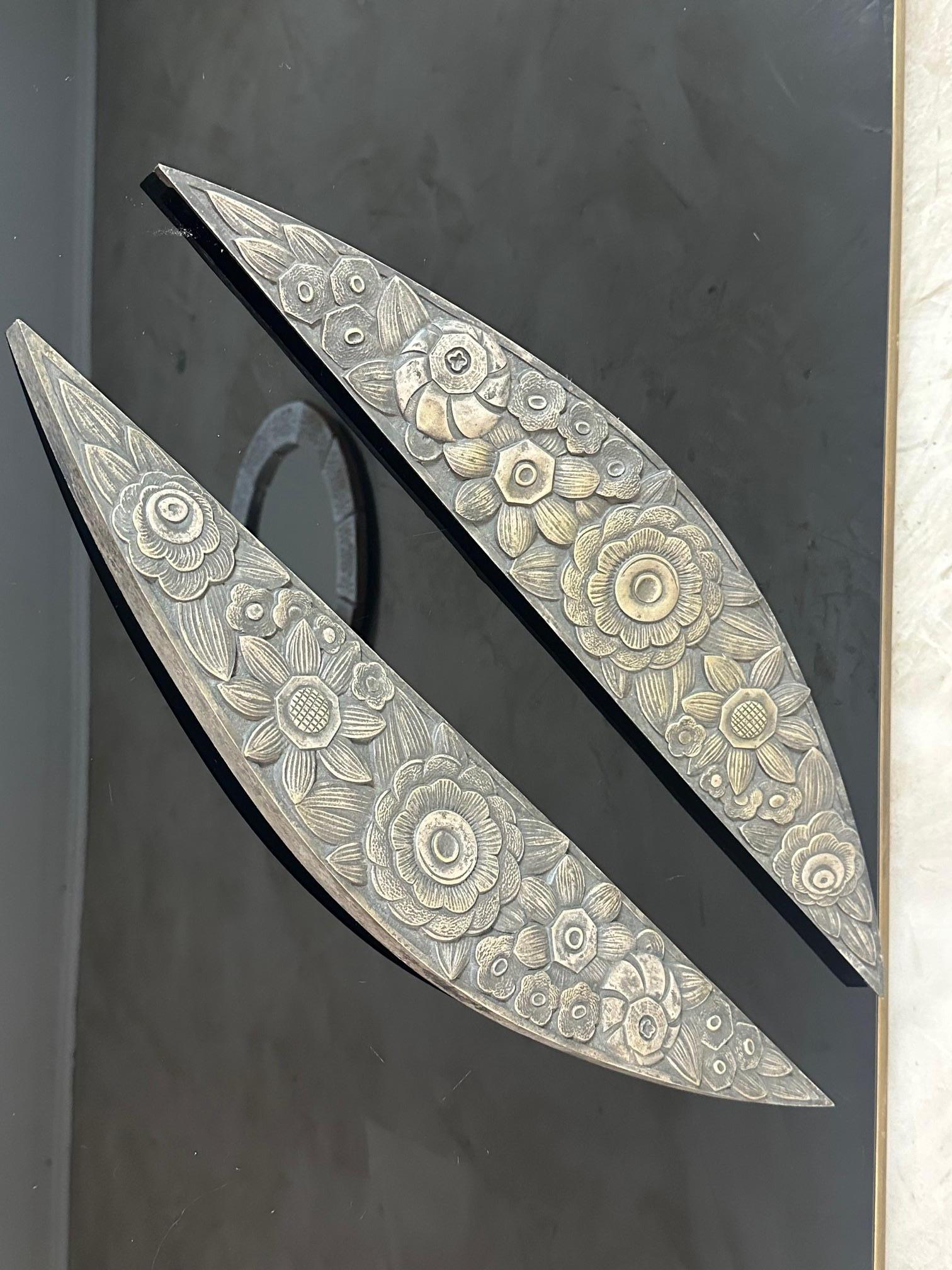 A stunning pair of solid bronze ornaments dating from the Art Deco period, featuring a delicate floral motif in relief, finely carved. These exceptional decorative elements can be used as wall decor accents, furniture handles, or architectural