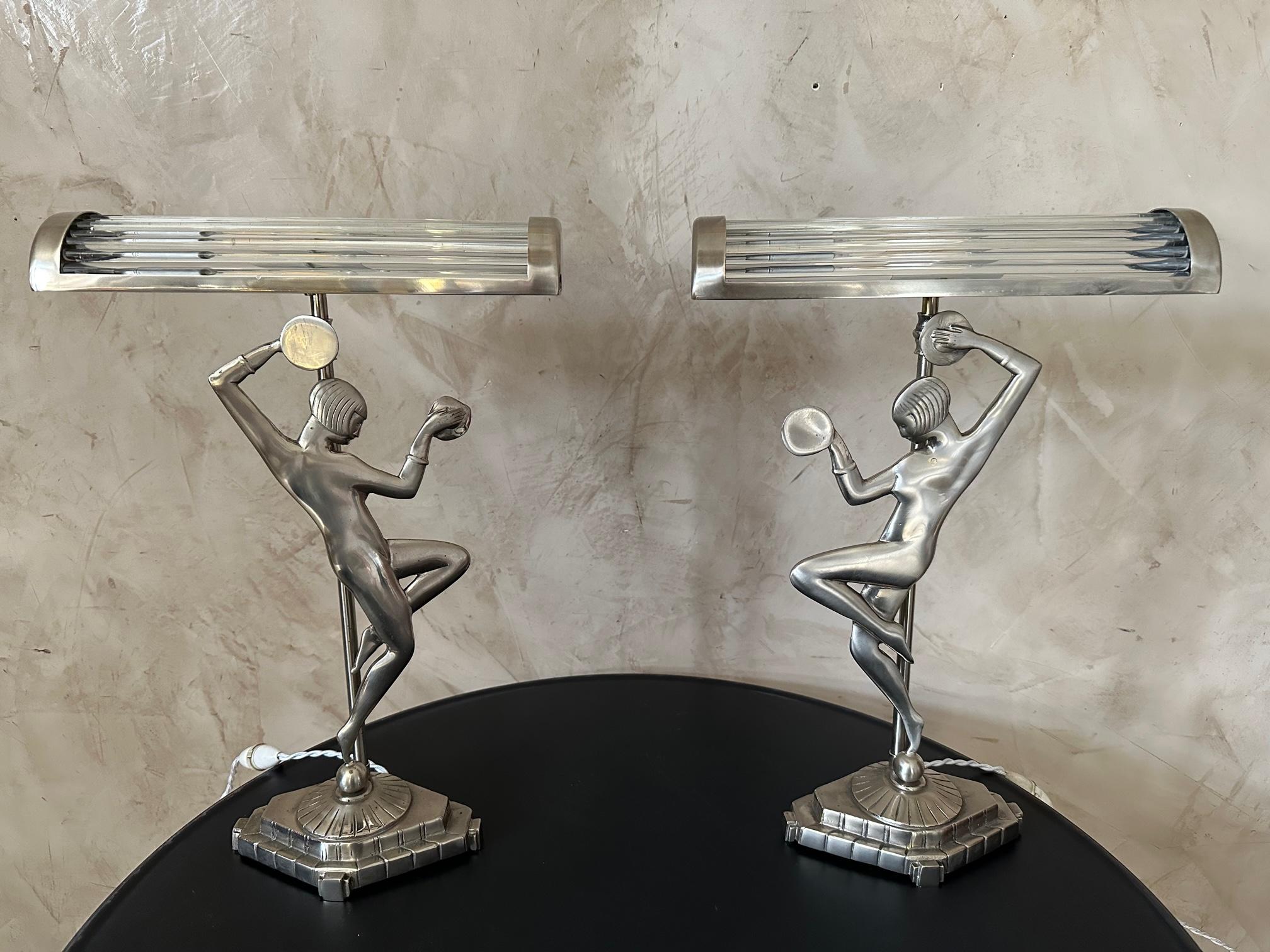 Very beautiful pair of art deco chrome metal lamps representing a woman dancing with timpani in her hands. Fully restored, re-nickeled and rewiring. 
Unique piece, creation of the glass lampshade.
Very good quality and perfect condition.
