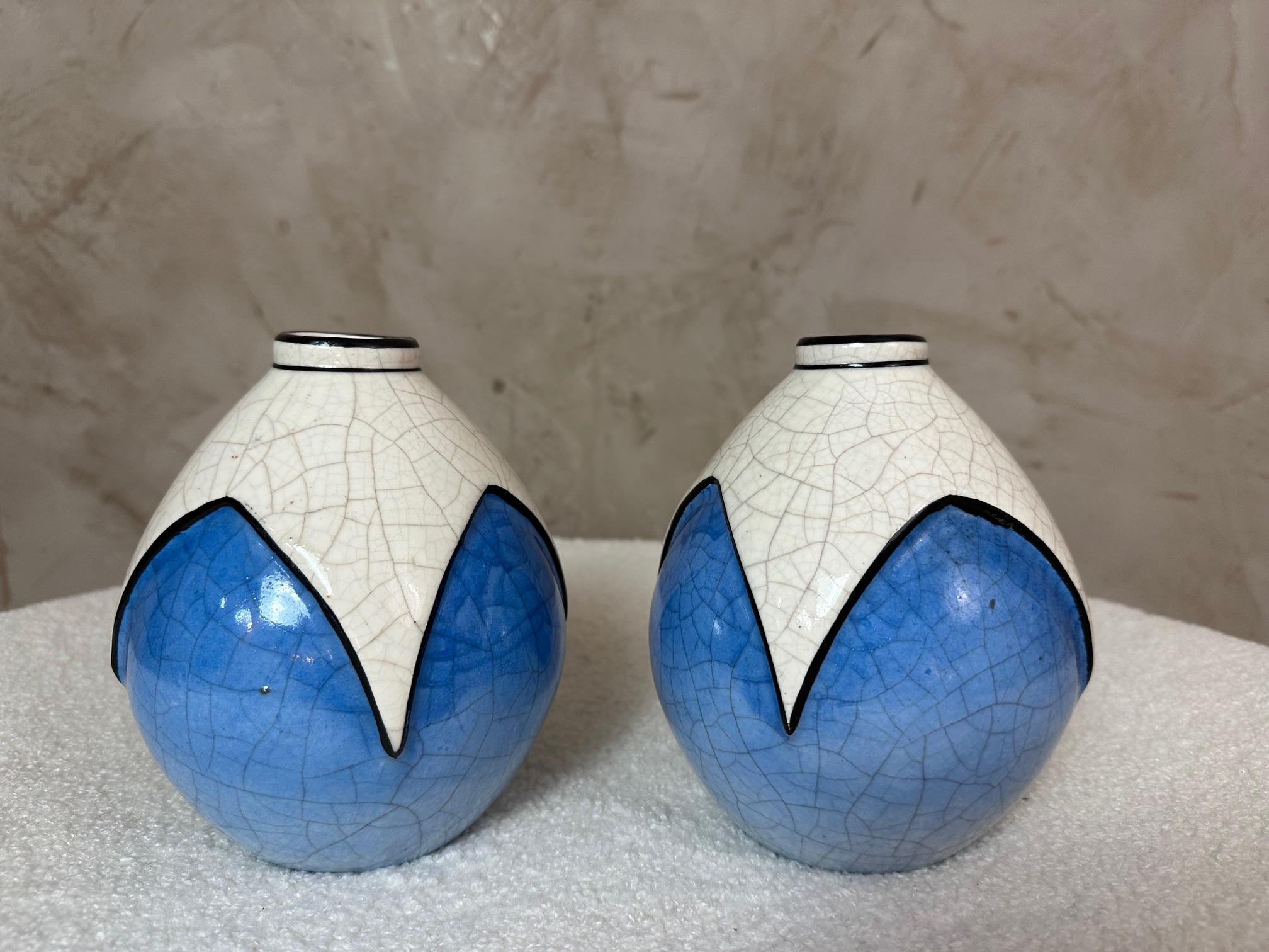 Charmante paire de petits vases Art Déco de la manufacture de Longwy, en faïence émaillée craquelée.
Décor géométrique stylisé et audacieux en blanc et bleu avec un fin contour noir - une esthétique moderniste typique de la période 1925-1935.

Belle