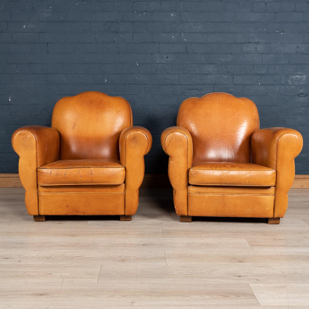 A lovely late 20th century pair of Art Deco style French leather club chairs. Wonderful patina and in fine vintage condition, structurally sound, these chairs perennially ooze class and sophistication. Extremely comfortable, they suit any style of