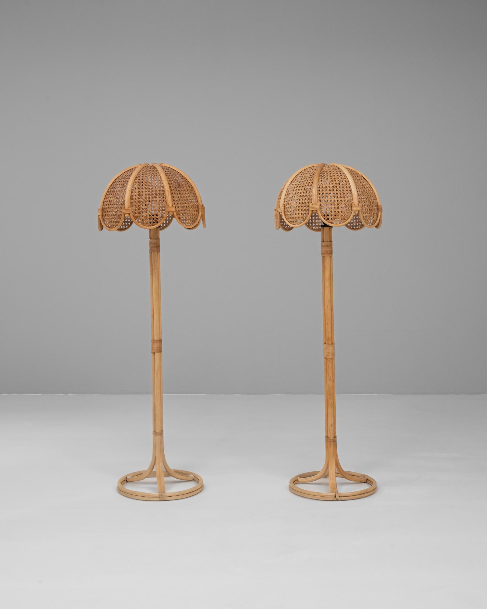 Cette paire de lampadaires en bambou du 20e siècle, d'origine française, dégage un charme chaleureux et naturel grâce à ses matériaux organiques et à son design ludique. Chaque lampe est fabriquée en bambou robuste avec une base circulaire qui