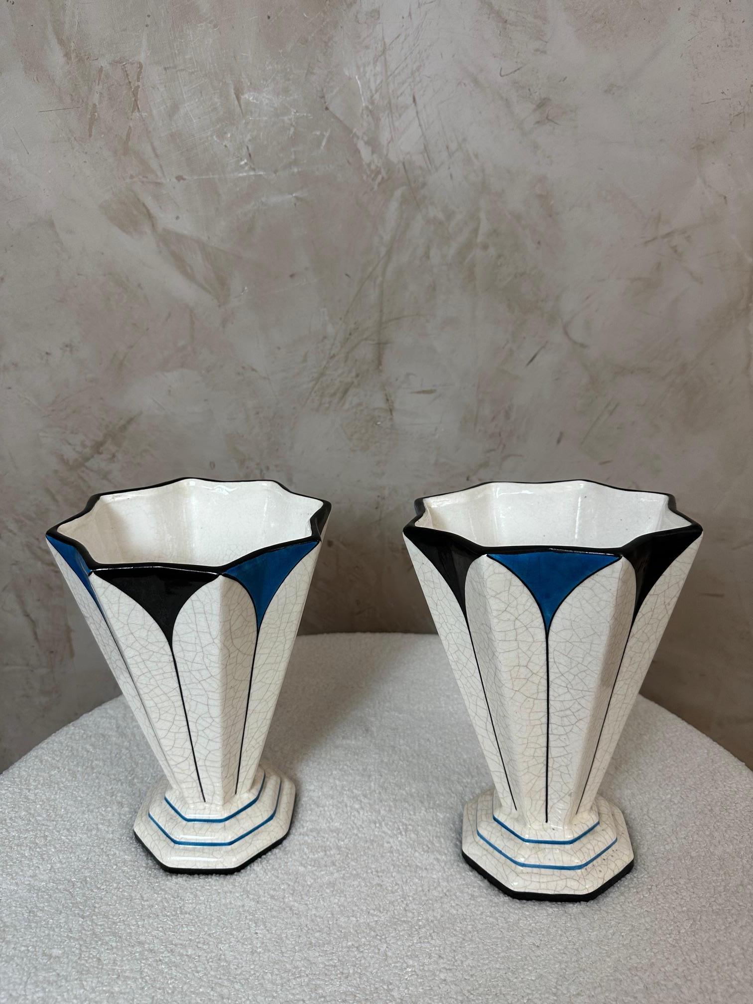 Superbe paire de vases Art Déco de la manufacture de Longwy, en faïence émaillée et craquelée, vers 1925-1935.

Le décor géométrique, typique du style moderne de l'entre-deux-guerres, alterne le noir, le bleu et le blanc, créant de grands motifs