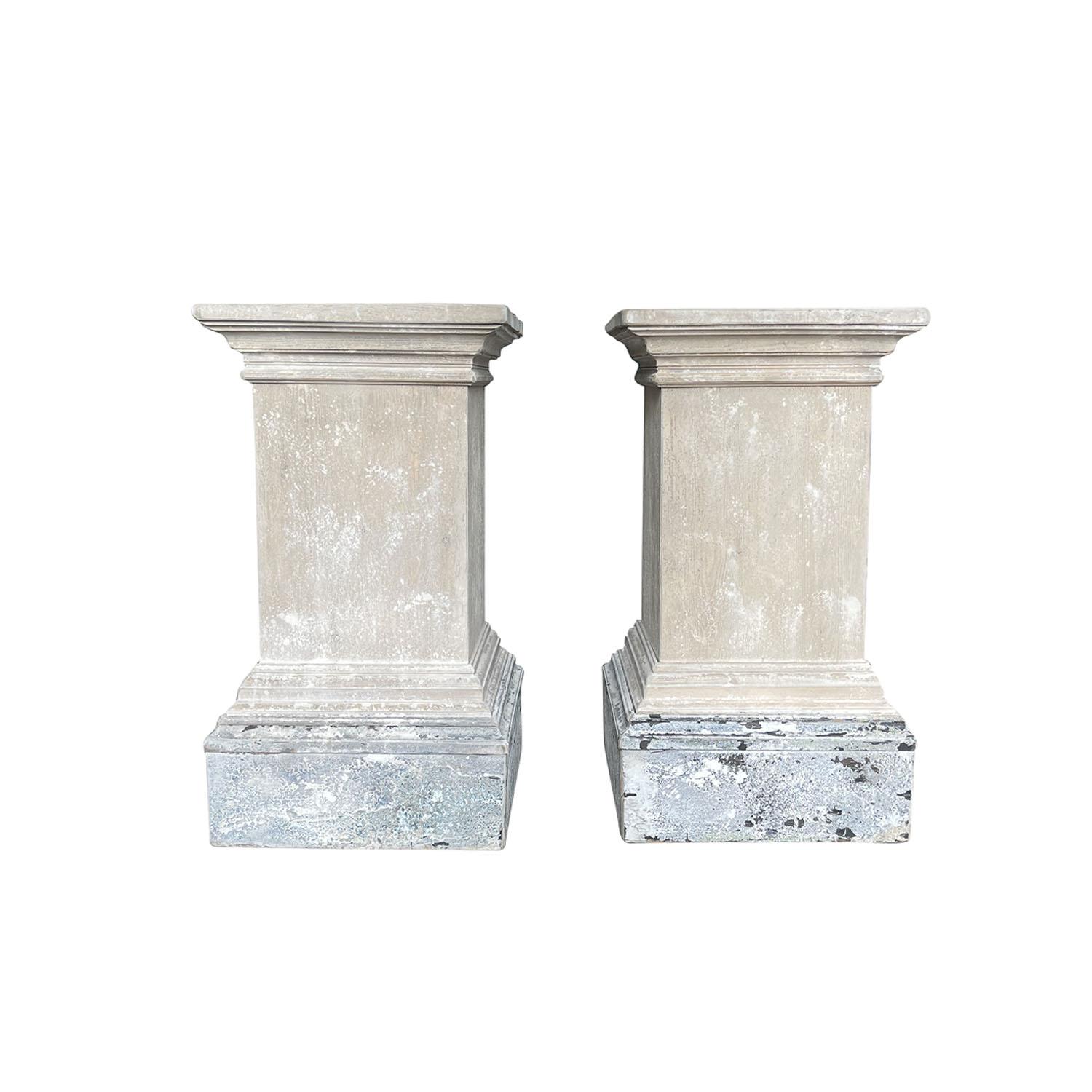 Ein blassgraues, altes französisches Paar quadratischer Sockel des 20. Jahrhunderts aus handgefertigtem Kiefernholz, mit schweren abgeschrägten Stufenleisten, in gutem Zustand. Die gealterte und warme Patina verleiht diesen architektonischen