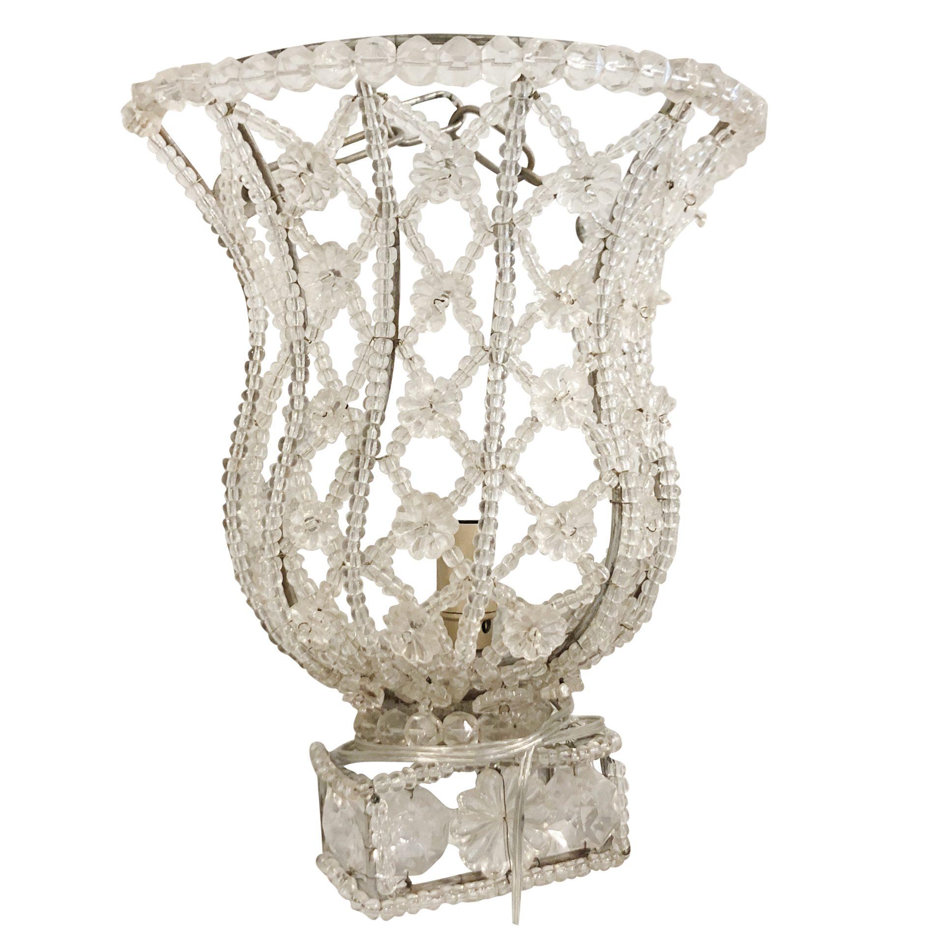 A vintage pair of French Art Deco wall fixtures made of hand blown cut crystal glass, in good condition. Each of the detailed prism glass pieces are supported by a chromed frame which is in of a basket. The Parisian wall appliques are composed with