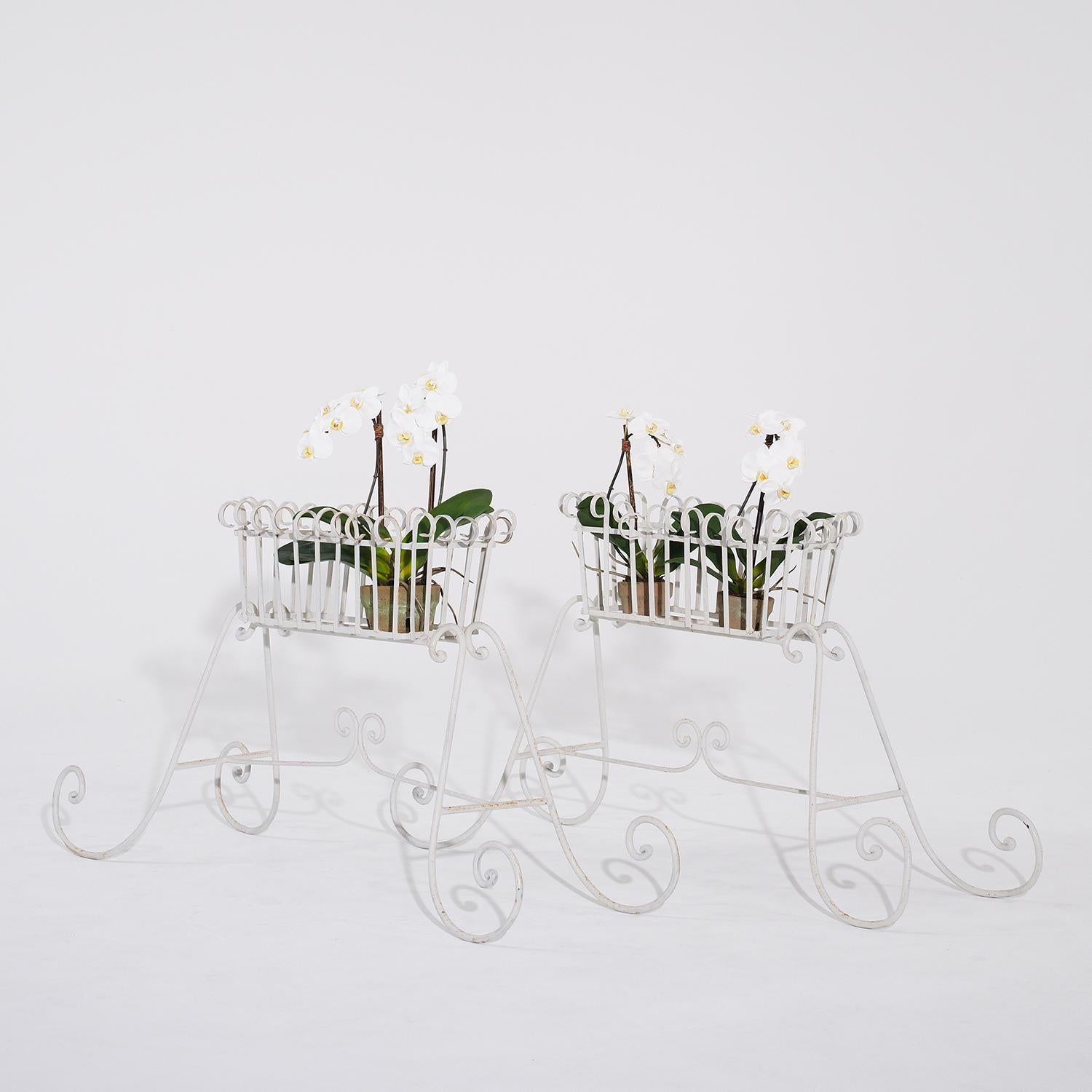 A vintage pair of French rectangular jardinieres, stands in white painted metal with wide flared scrolled bases and decorative rim, in good condition. Minor fading, scratches due to age. Wear consistent with age and use. Circa 1920 - 1930,
