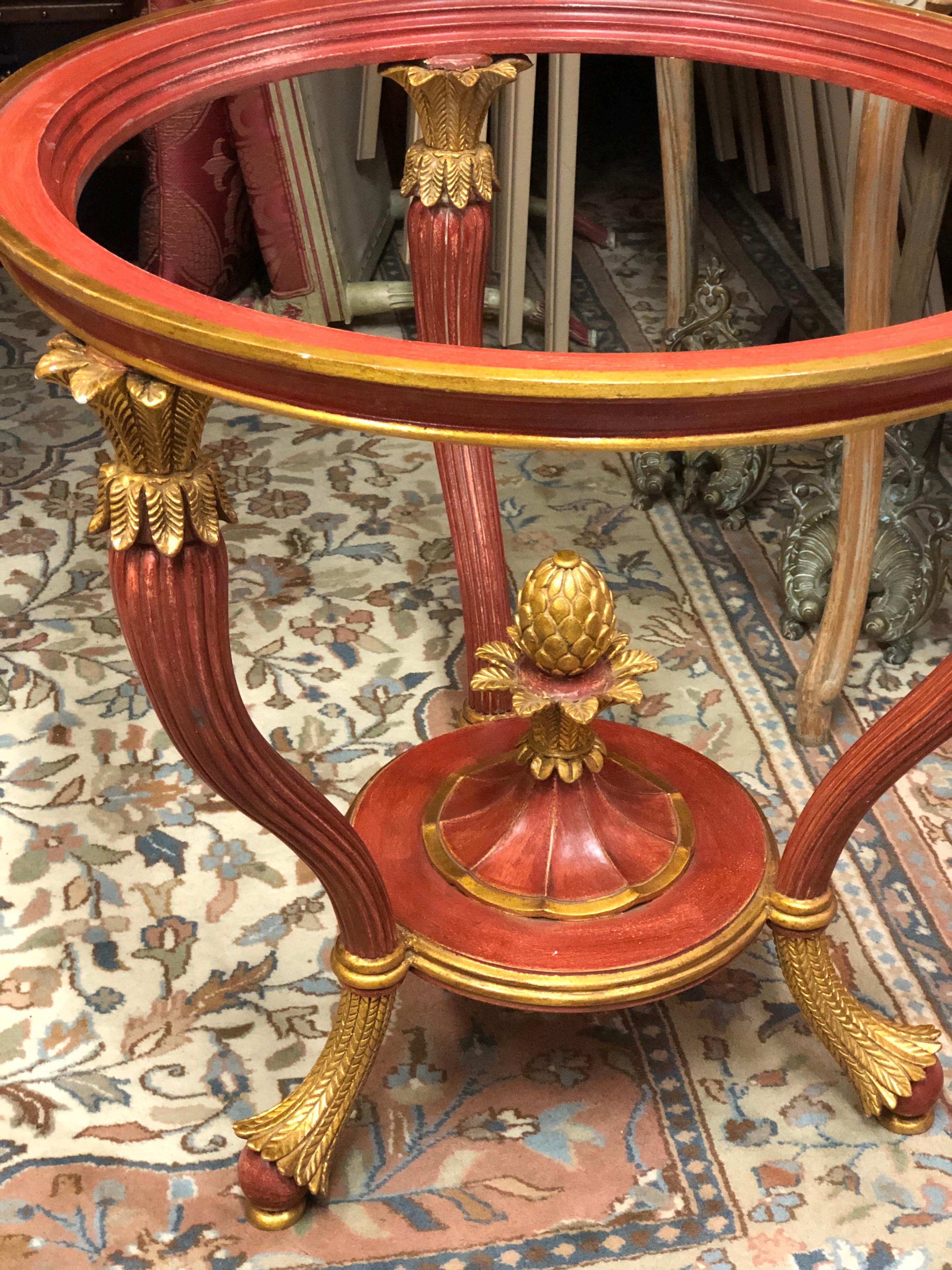 French pedestal table in carved, molded and painted in red and gold wood. It rests on a curved and fluted tripod base surmounted by stylized acanthus leaves, and joined by a spacer ending in a pine cone.
Glass top
Circa 1920.